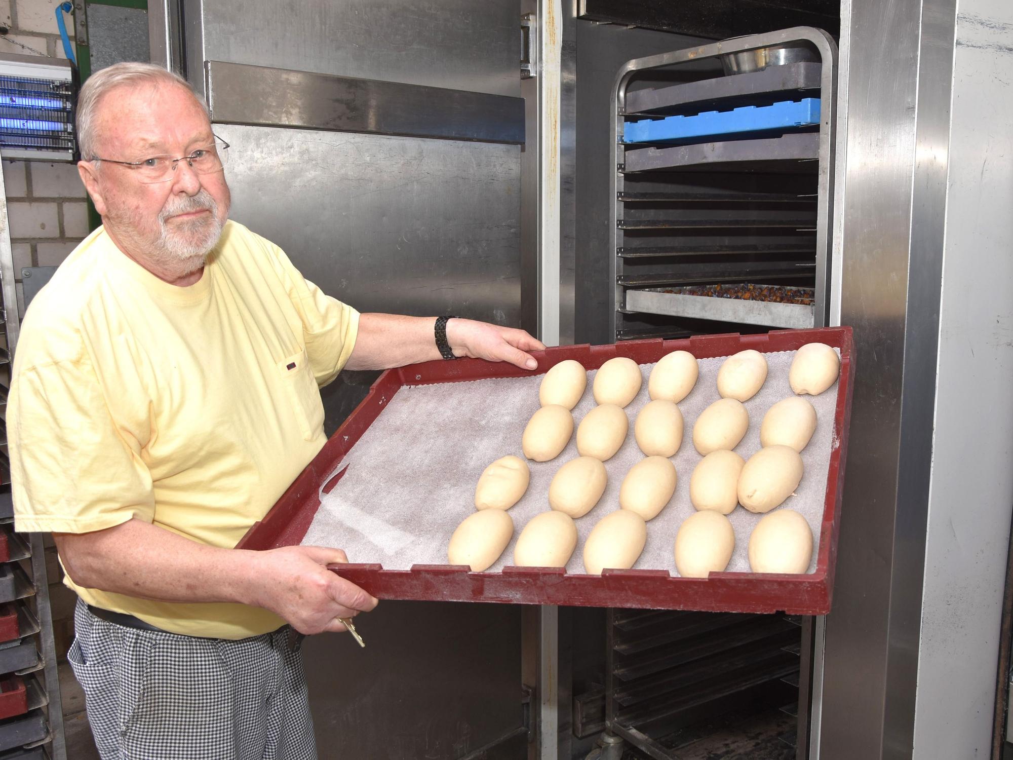 Das Bild zeigt Bäckermeister Willi Immerath mit einem Blech Brötchen.
