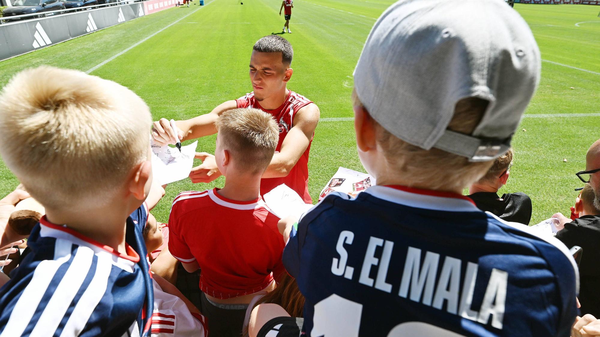 Said El Mala schreibt Autogramme für junge FC-Fans beim Training.