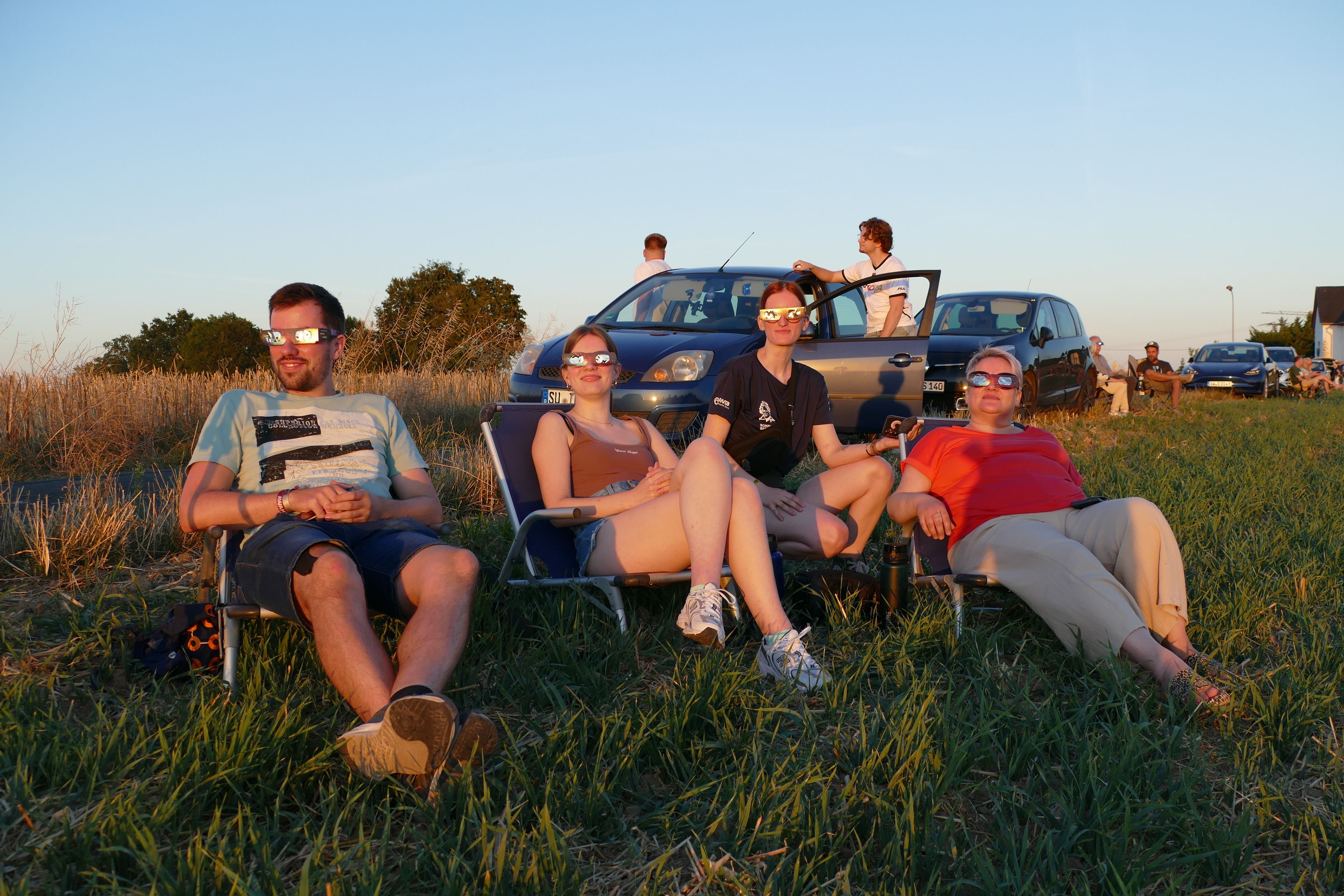 Leon, Louisa, Emma und Anja (v.l.n.r.) beobachteten die Sonnenfinsternis in Halberg auf Campingstühlen.