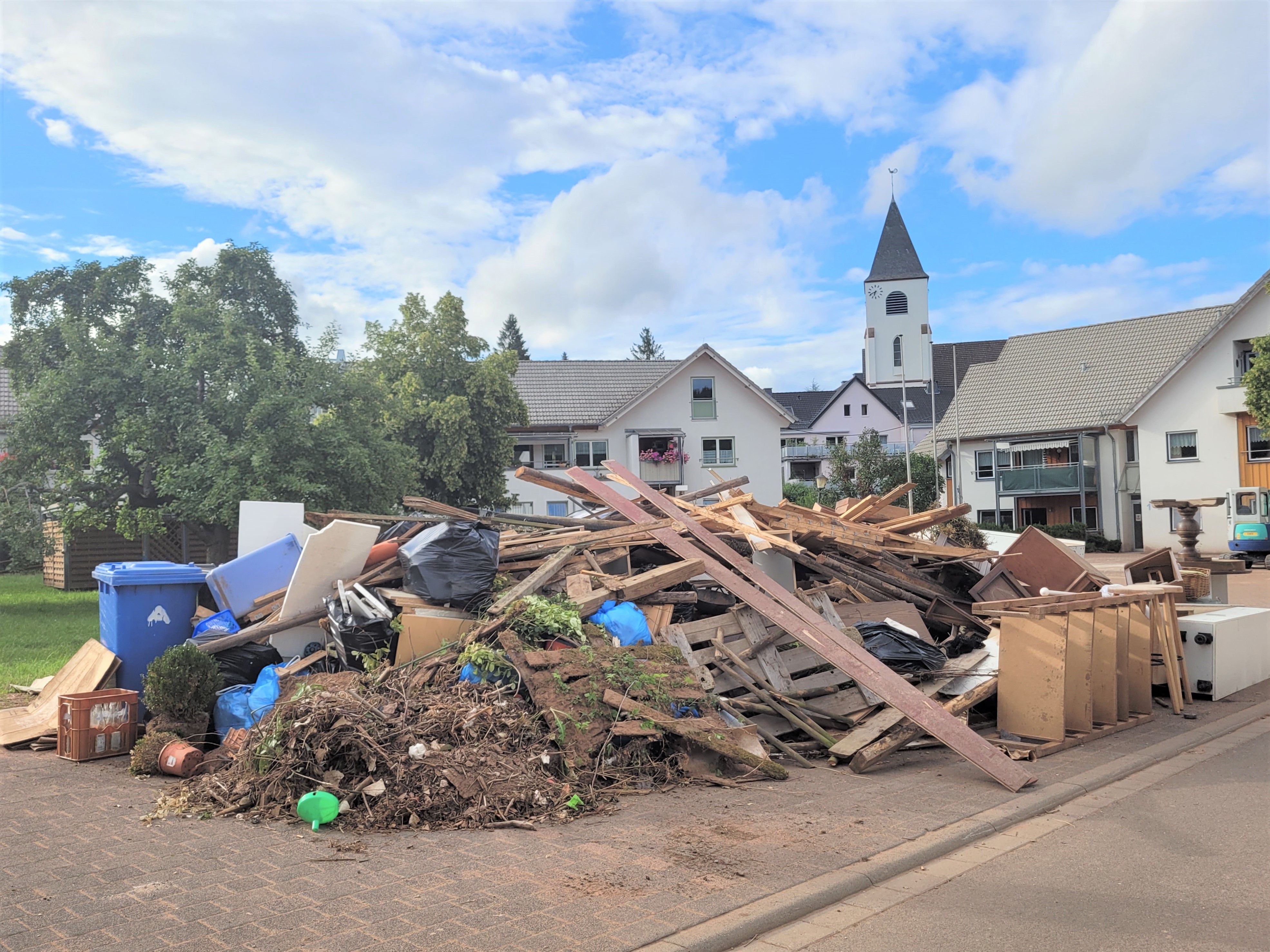 Ein Schuttberg liegt neben dem Markt in Kall. Im Hintergrund ist die Kirche zu sehen.