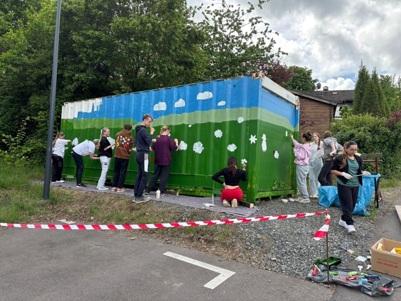 In Hermesdorf, Waldbröl, haben Jugendliche von der Gesamtschule auf Einladung des Verschönerungsvereins einen trsiten Container in ein farbenfrohes Kunstwerk verwandelt.