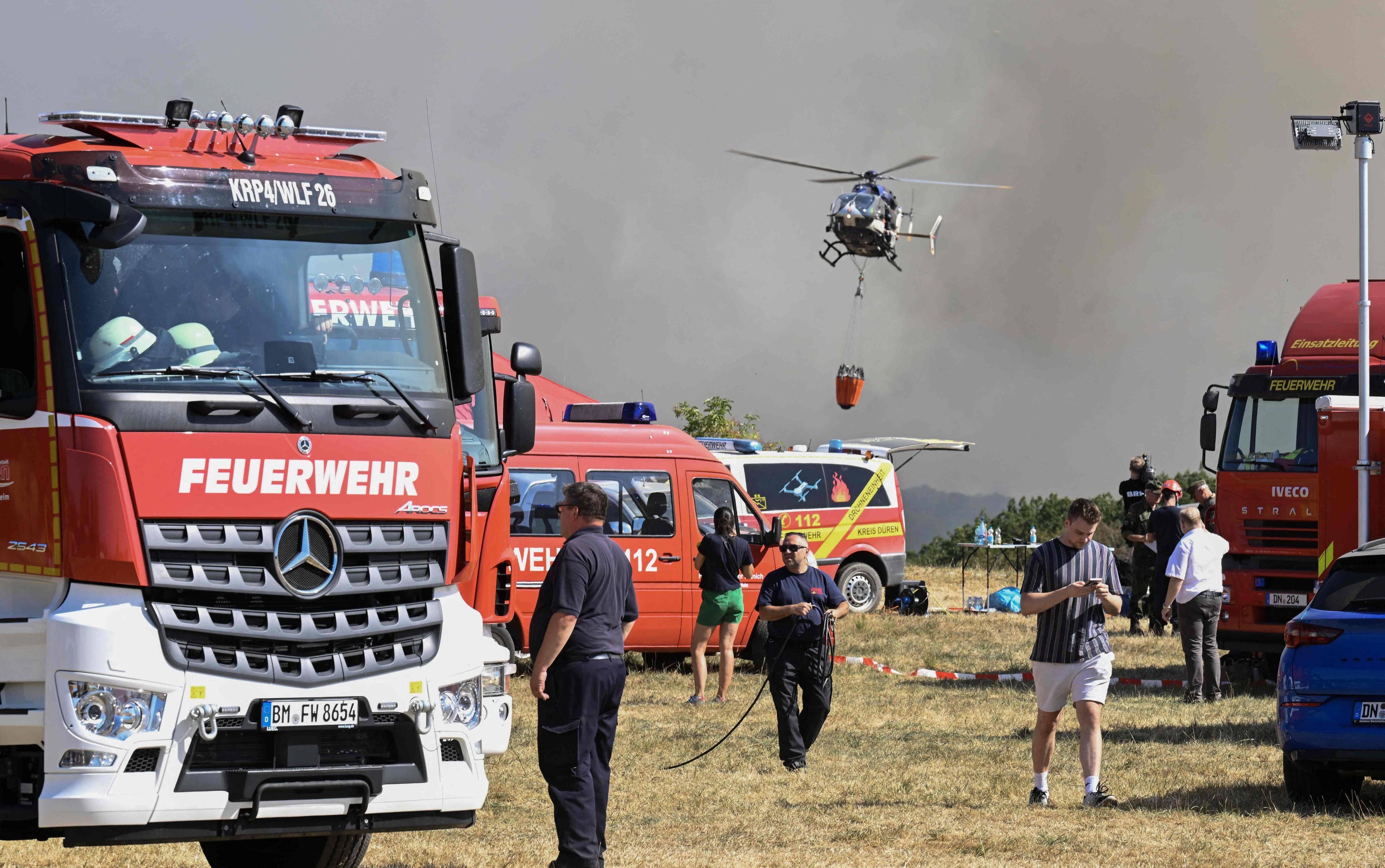 Das Bild zeigt Einsatzkräfte und -fahrzeuge der Feuerwehr am Sammelplatz bei Hürtgenwald.