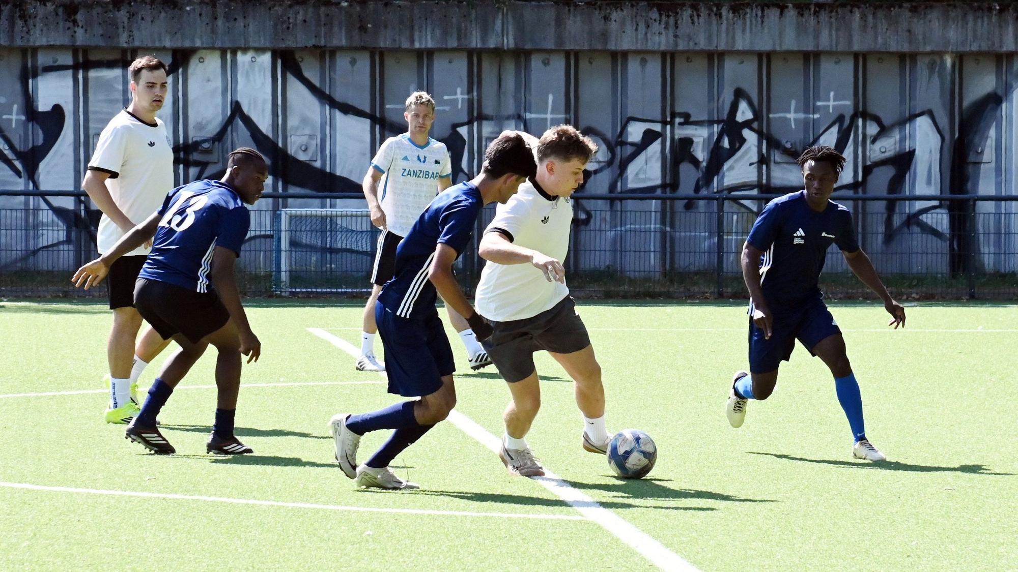 Zwei der zwölf Mannschaften duellieren sich im Gruppenspiel im Stadion des ESV Olympia in Nippes. Im Bild sind sechs Spieler rund um den Ball.