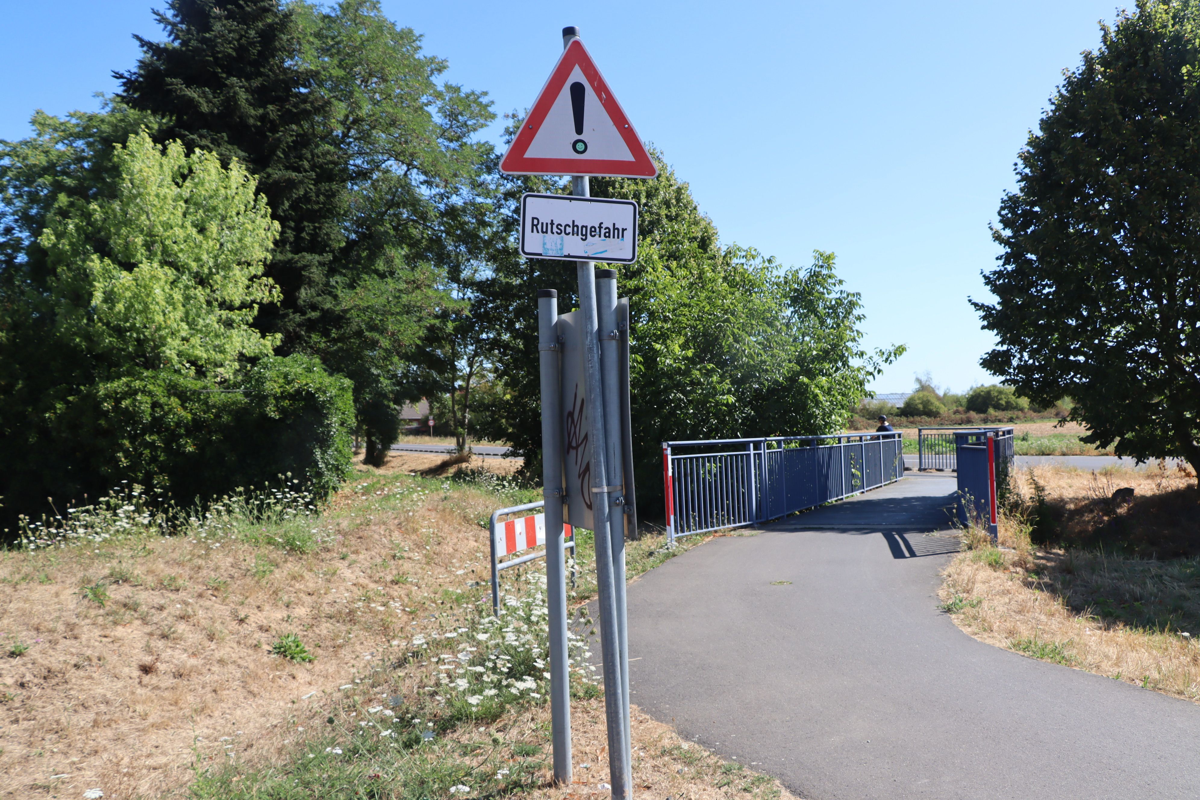 Zu sehen ist eine Brücke, davor ein Schild.