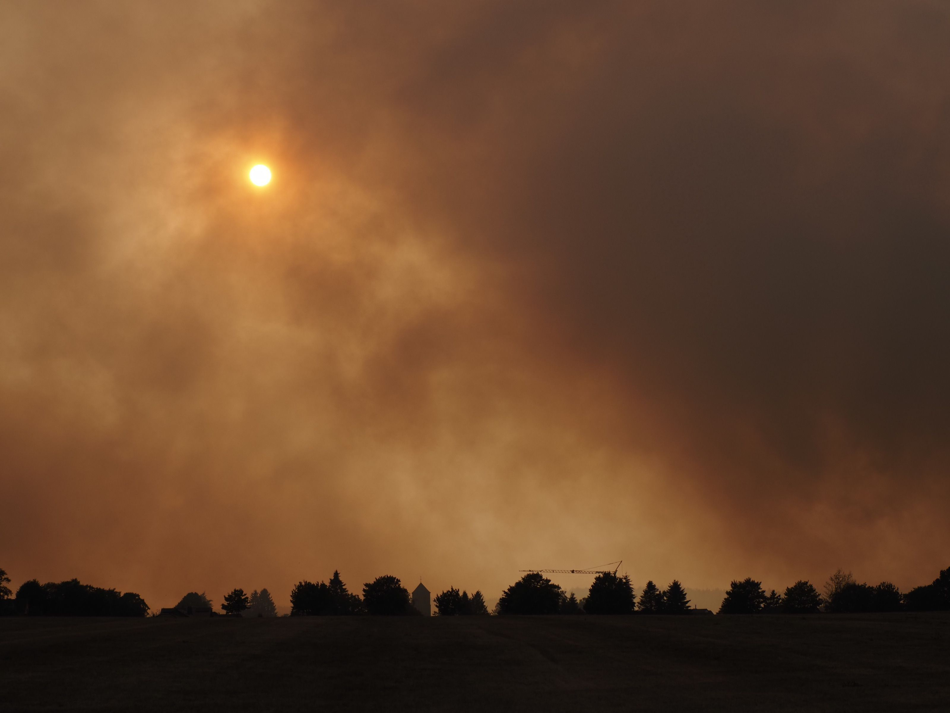 Der Rauch des Waldbrandes hängt in der Luft über dem Ortsteil Großhau in Hürtgenwald.