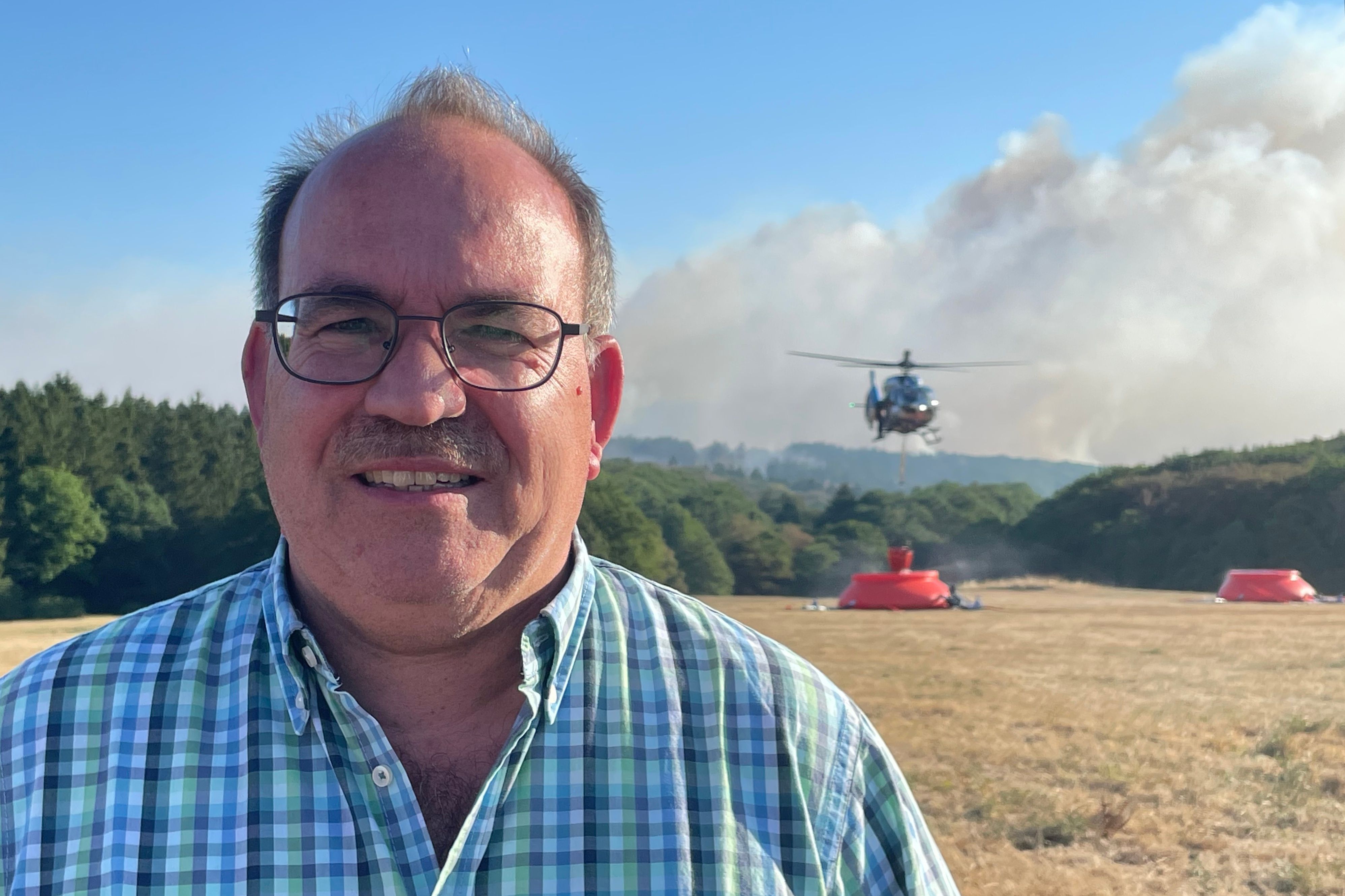 Ralf Nolten (CDU), Landrat vom Kreis Düren, spricht unweit des Waldbrands im Hürtgenwald.