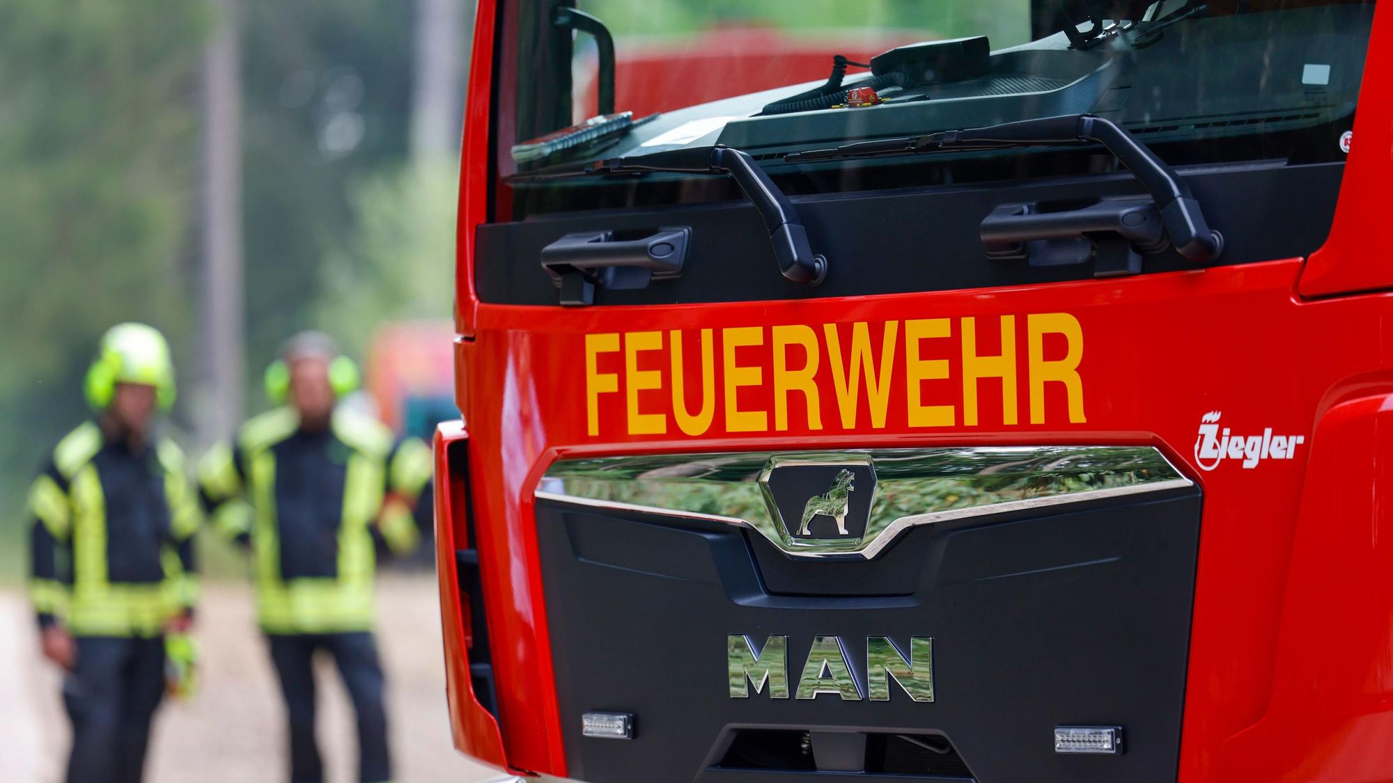 Ein Einsatzfahrzeug der Feuerwehr steht in einem Waldgebiet.