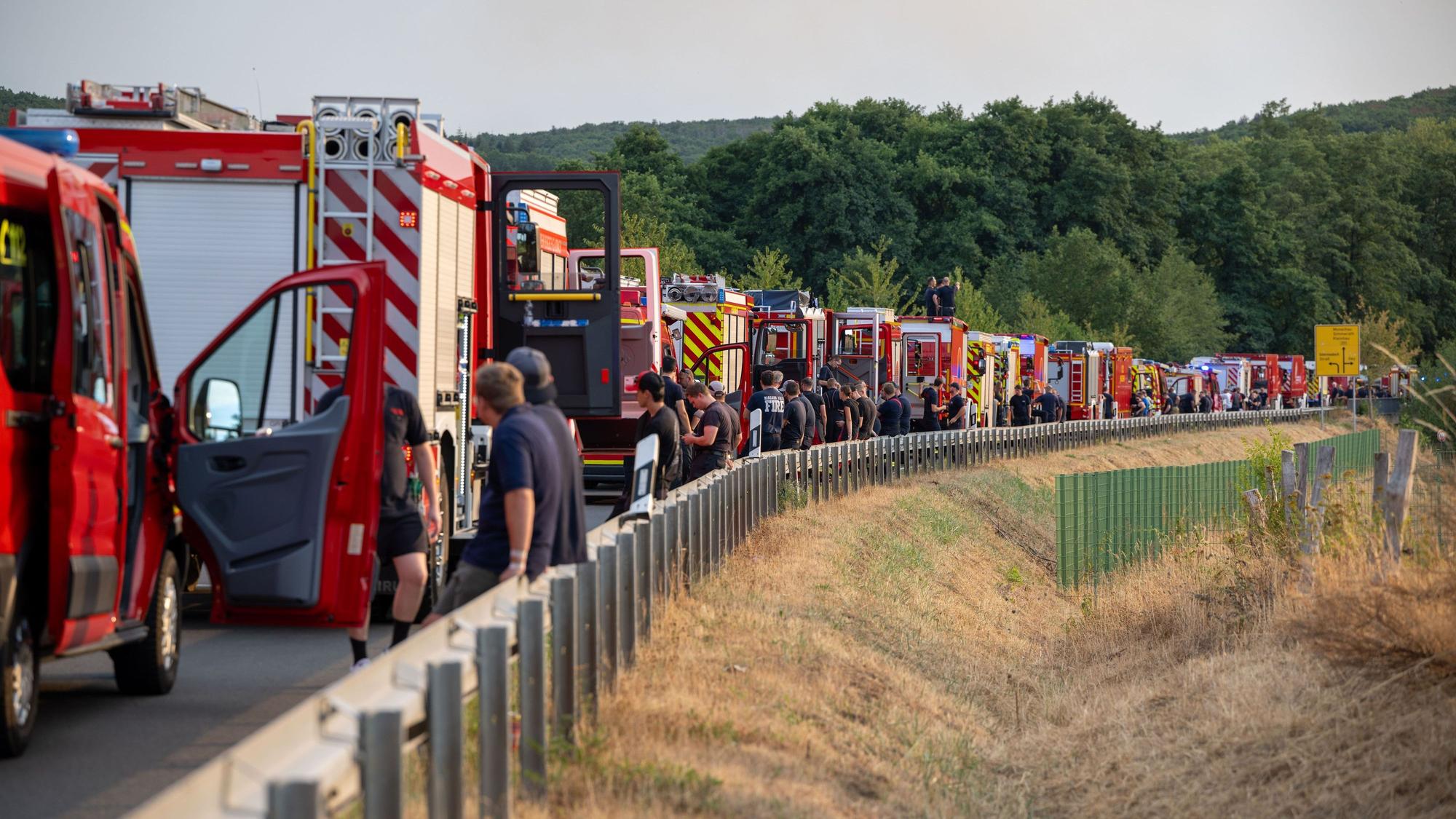 dpatopbilder - 14.08.2026, Nordrhein-Westfalen, Hürtgenwald: Einsatzkräfte der Feuerwehr warten auf der B399 bei Hürtgenwald-Gey. Foto: Harald Tittel/dpa +++ dpa-Bildfunk +++