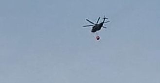 Ein Hubschrauber fliegt am Samstagmorgen Richtung Hürtgenwald zum Löscheinsatz und überquert dabei Köln-Bocklemünd.