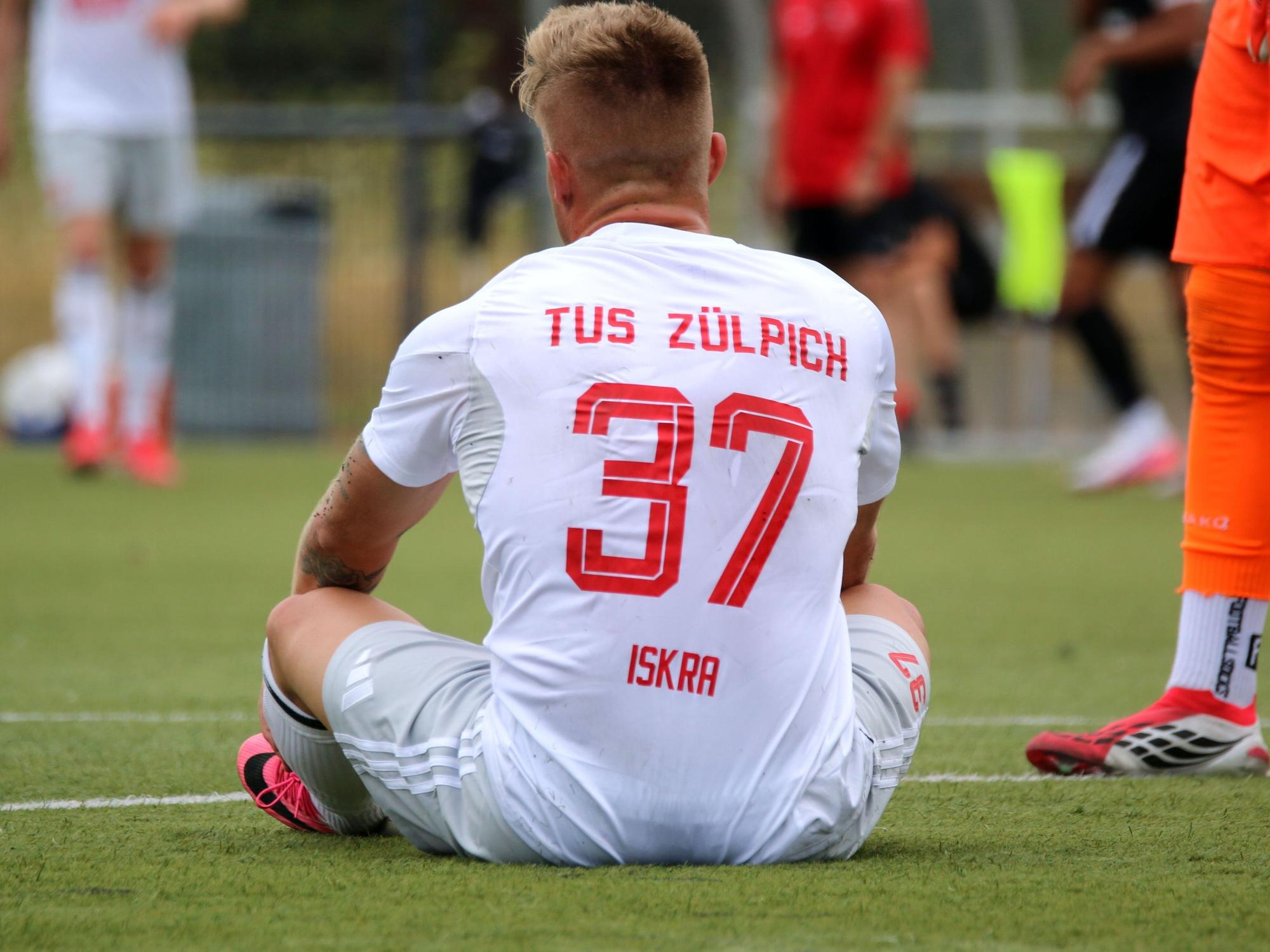 Marvin Iskra sitzt auf dem Boden. Auf dem Trikot steht nun nicht nur die Rückennummer, sondern auch sein Name.