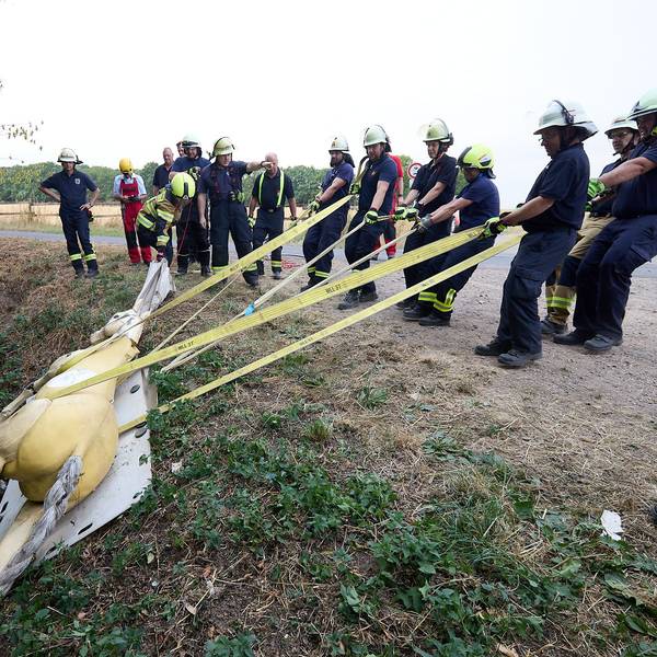 Feuerwehrleute ziehen den Pferdedummy aus einem Graben.