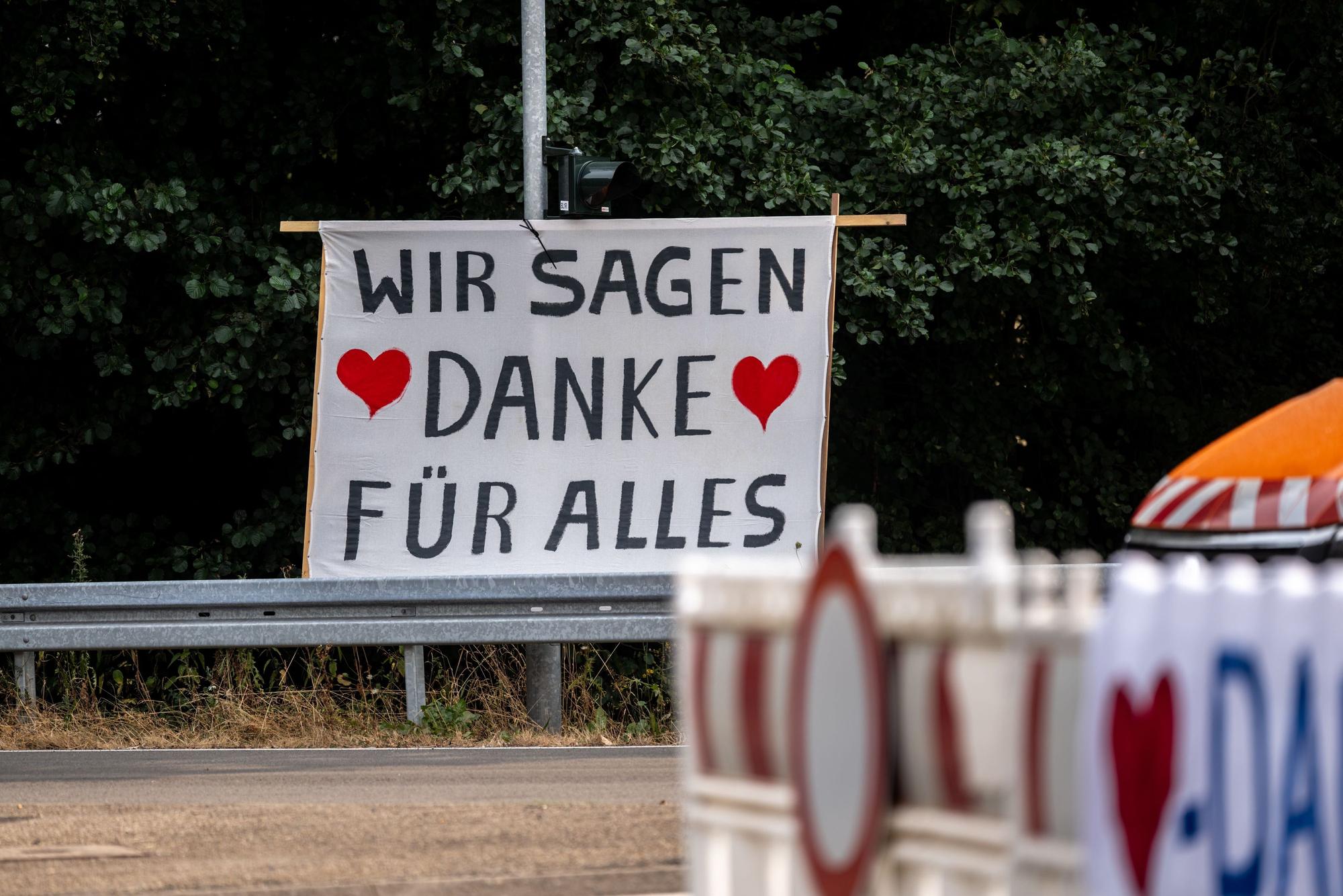 16.08.2026, Nordrhein-Westfalen, Hürtgenwald: Die Bewohner der Ortschaft Gey danken den Rettungskräften für den Einsatz im Waldbrandgebiet im Hürtgenwald mit einem Transparent mit der Aufschrift „Wir sagen Danke für alles“. Seit 15.08.2026 können die Menschen nach der Evakuierung wieder offiziell zurückkehren. Foto: Christian Knieps/dpa +++ dpa-Bildfunk +++