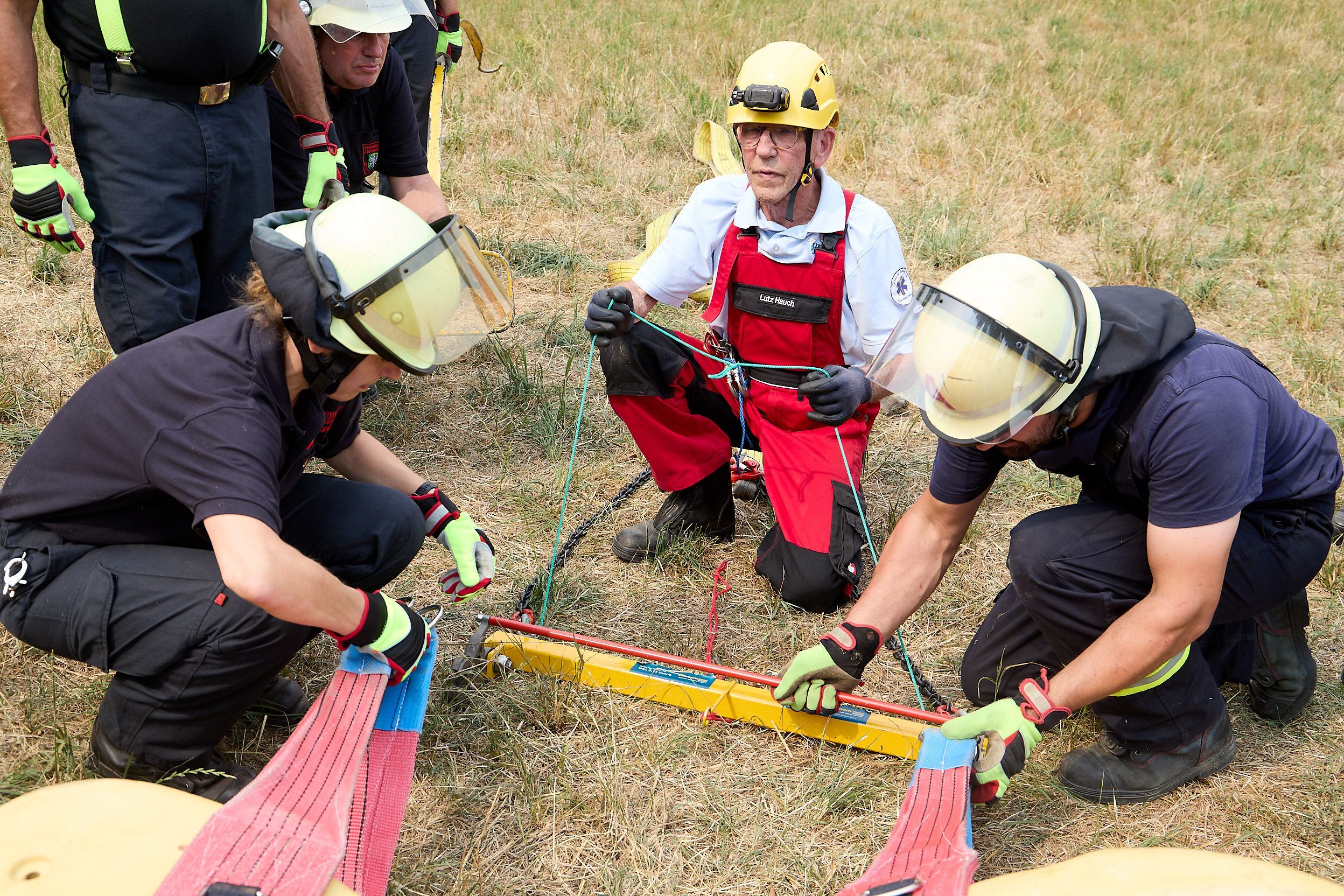 Zwei Feuerwehrleute befestgen ein Geschirr am Pferd.