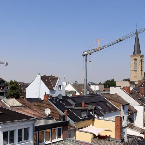 Über den Dächern der Stadt Euskirchen erheben sich zwei Baukräne, rechts ist die Herz-Jesu-Kirche zu sehen.