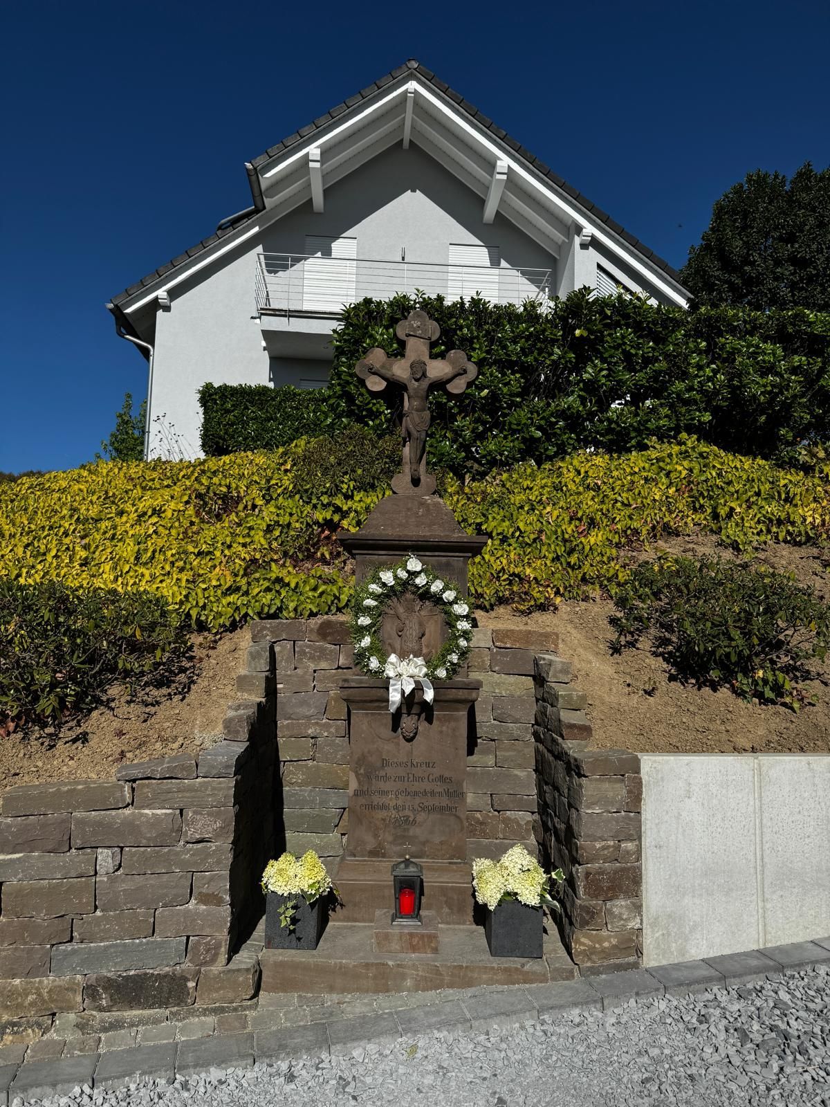 Ein Hofkreuz steht in der Sonne