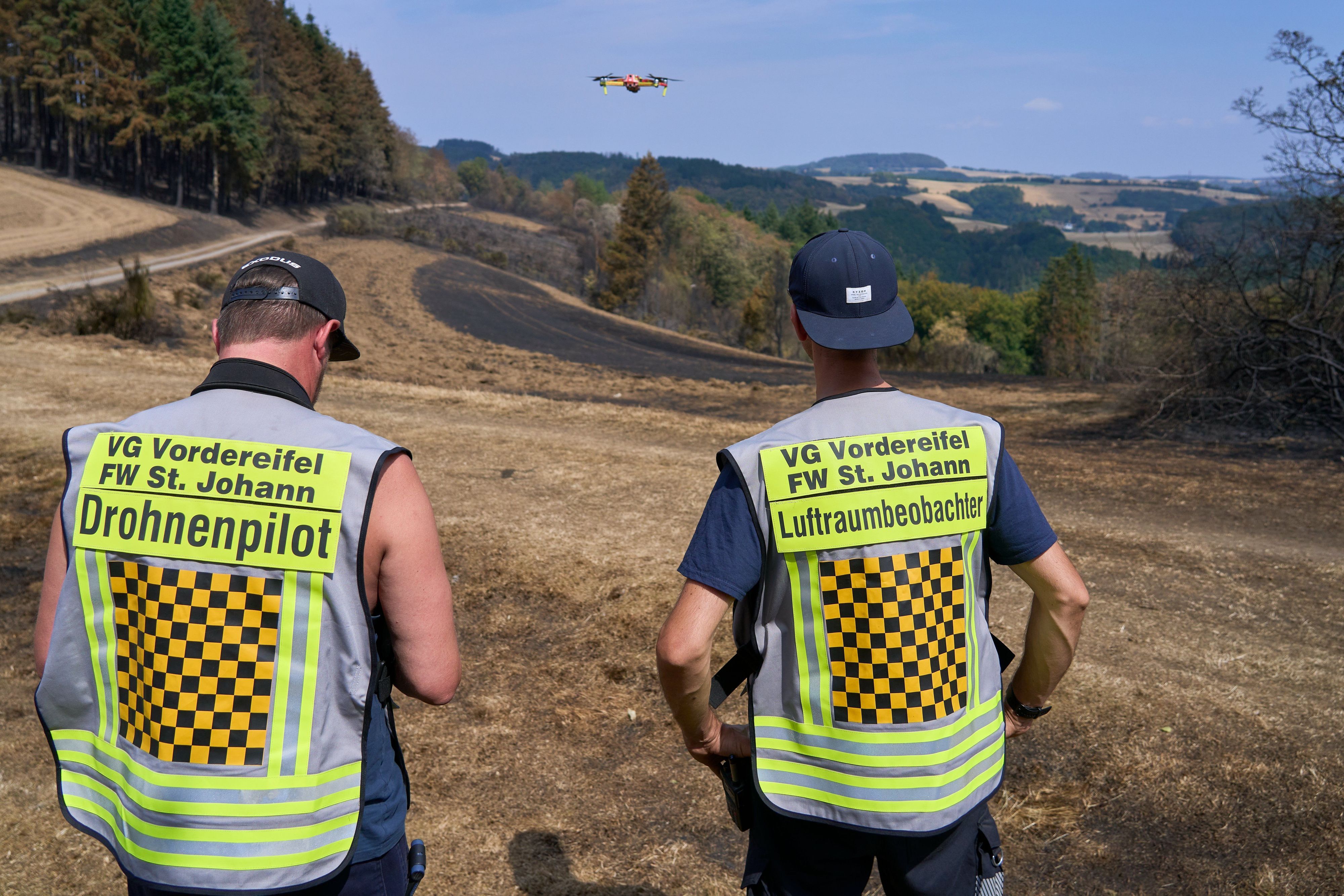 Langscheid in der Eifel: Mit der Wärmebildkamera suchen zwei Feuerwehrleute das Gelände nach Glutnestern ab.