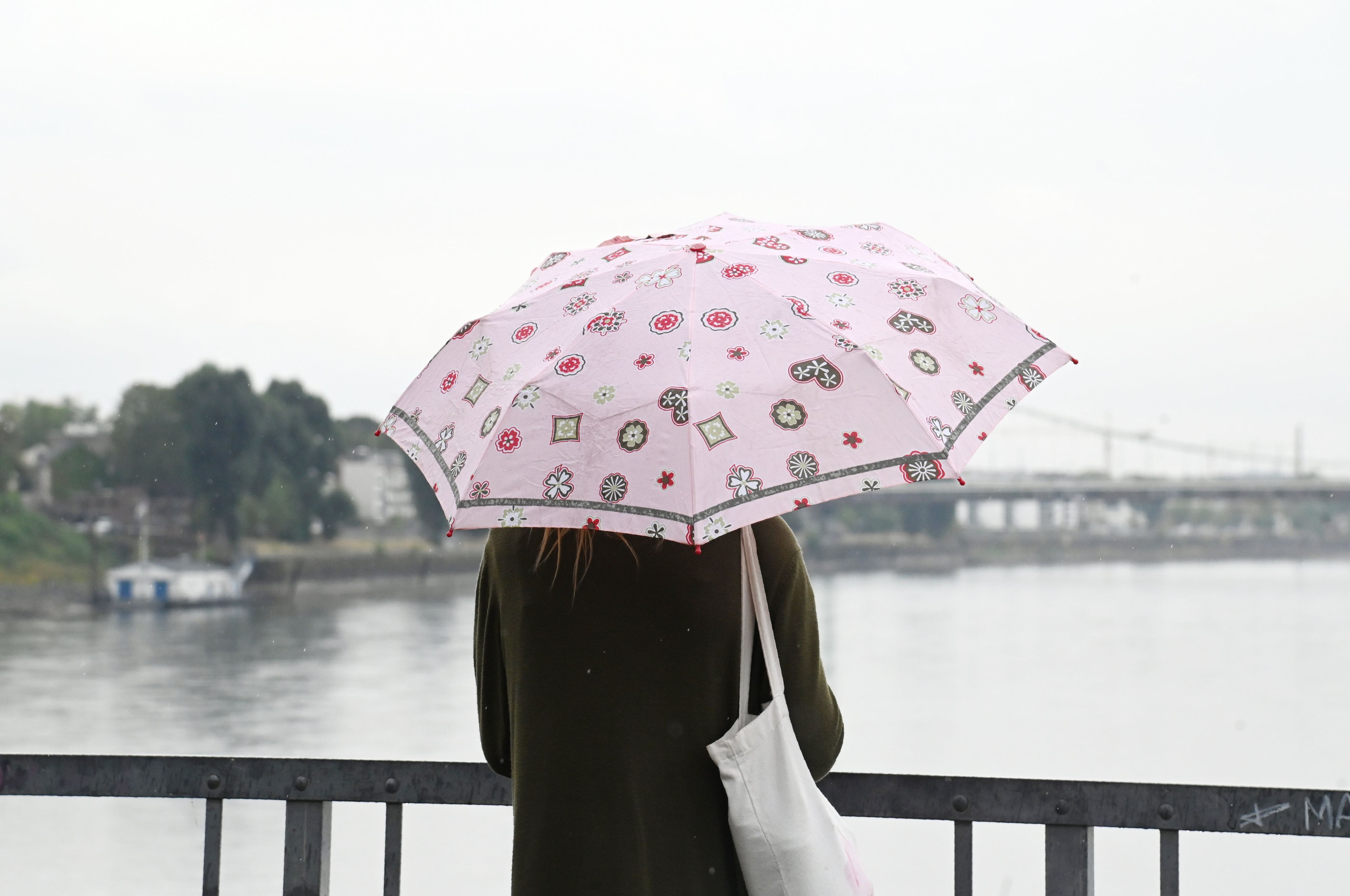 Endlich Regen: Eine Frau mit Regenschirm am Rheinufer in Mülheim.