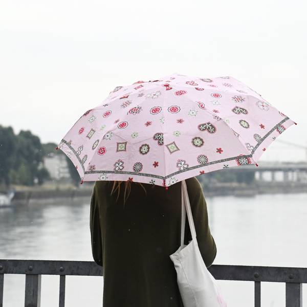 Endlich Regen: Eine Frau mit Regenschirm am Rheinufer in Mülheim.