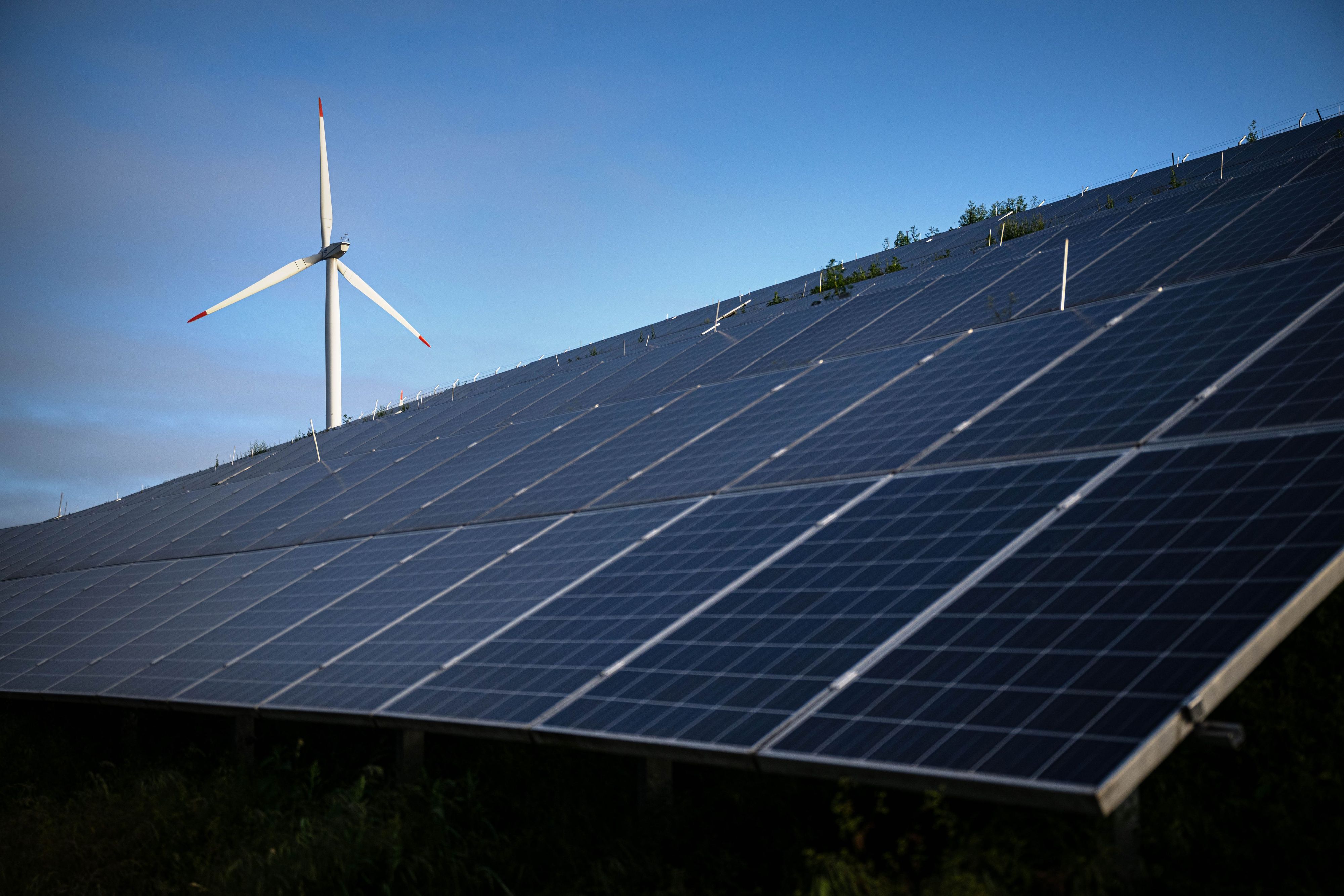 Windkraftanlagen stehen hinter Photovoltaikanlagen auf der Blocklanddeponie.