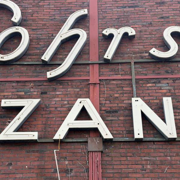 Leuchtstoffröhren hängen zerstört vom Schriftzug „Gohrsmühle Zanders“ herunter.