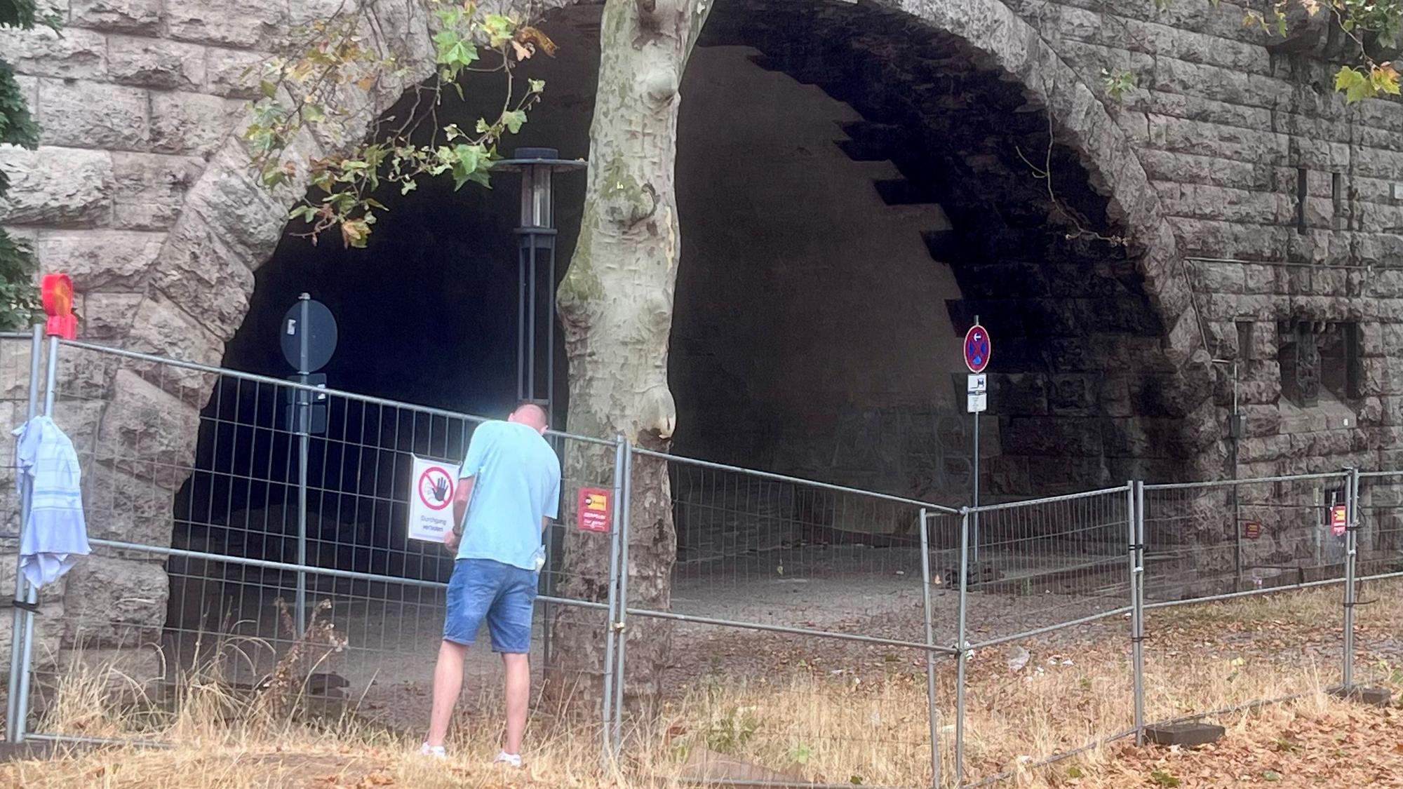Am Montag standen die Absperrgitter wieder dicht an dicht vor der Unterführung. Im Auftrag der Stadt hängt ein Mann Schilder mit der Aufschrift „Durchgang verboten“ auf.