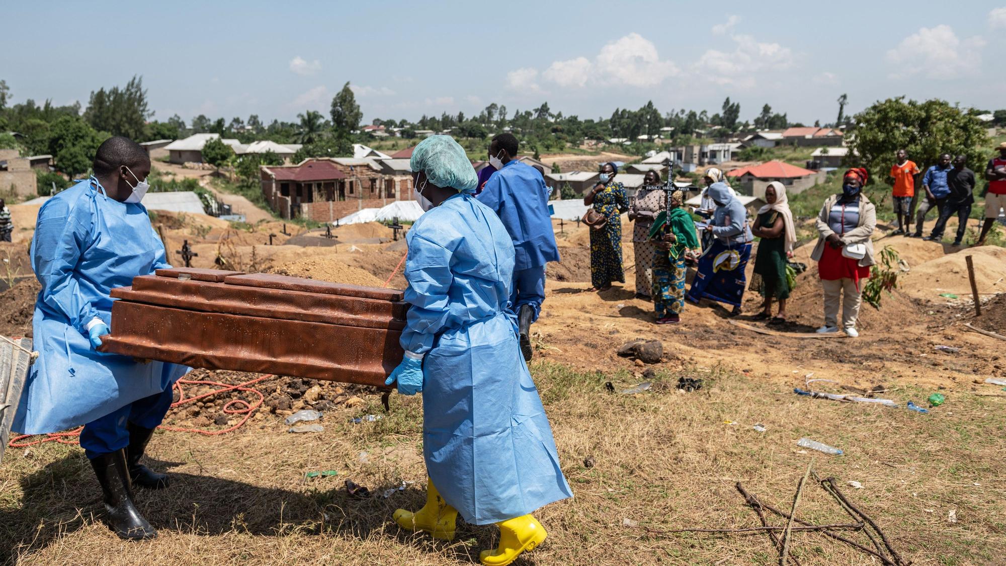 Mitarbeiter des Roten Kreuzes bereiten sich darauf vor ein sechs Monate altes, durch Ebola verstorbenes Waisenmädchen, auf dem Bigo-Friedhof beizusetzen.