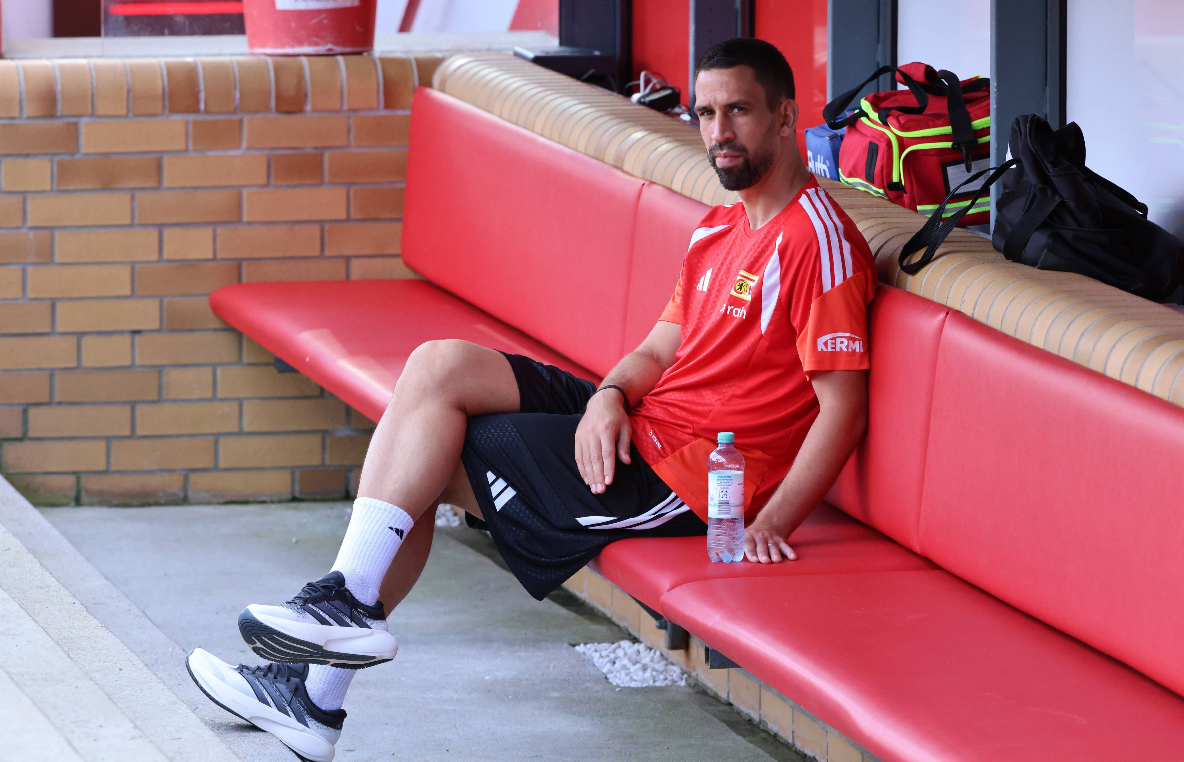 Rani Khedira sitzt entspannt auf der Bank.