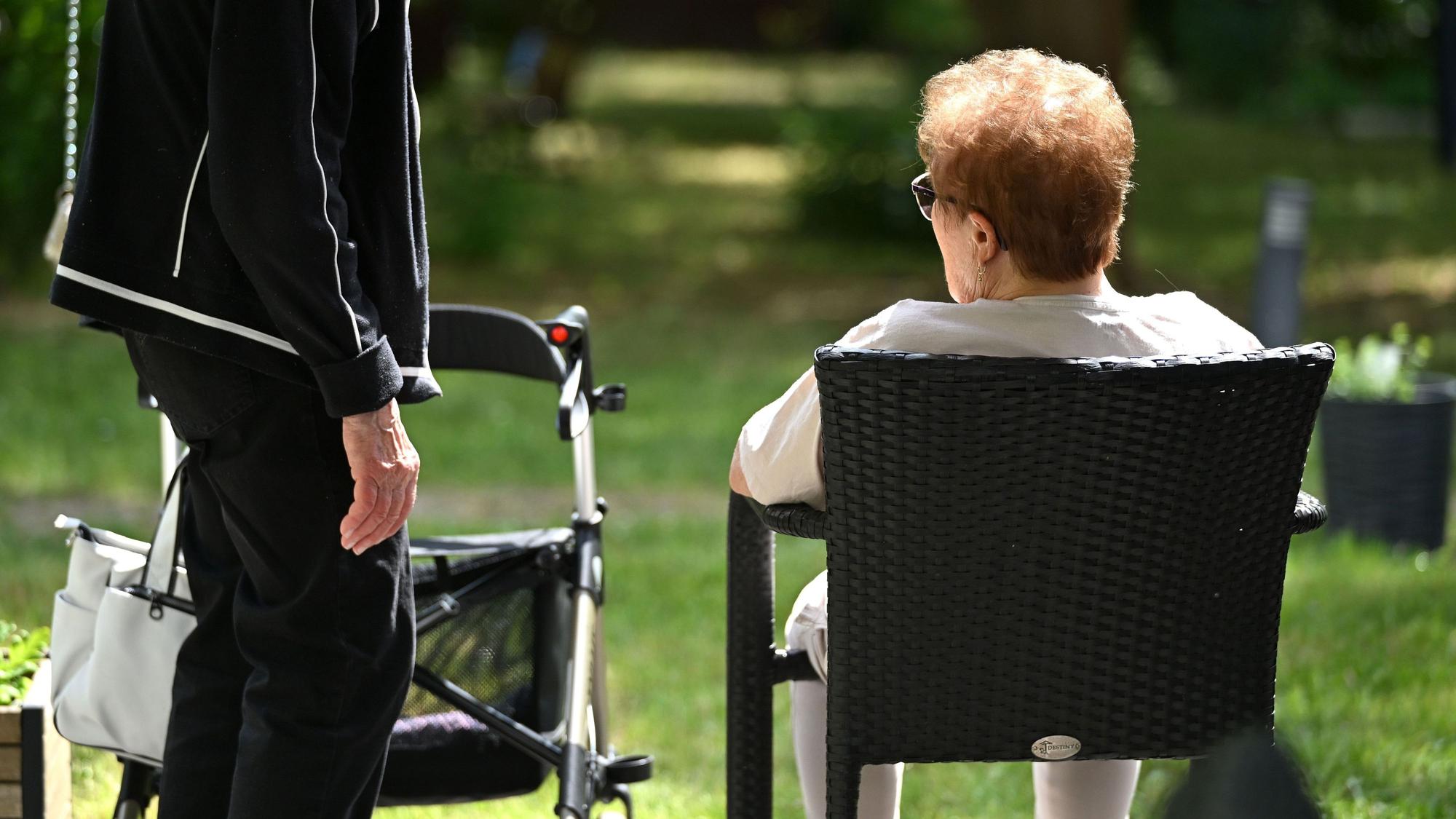 Zwei Senioren sprechen in dem Garten eines Pflegeheims miteinander. Hitze stellt insbesondere für ältere und pflegebedürftige Menschen ein Risiko dar. (Archivbild)