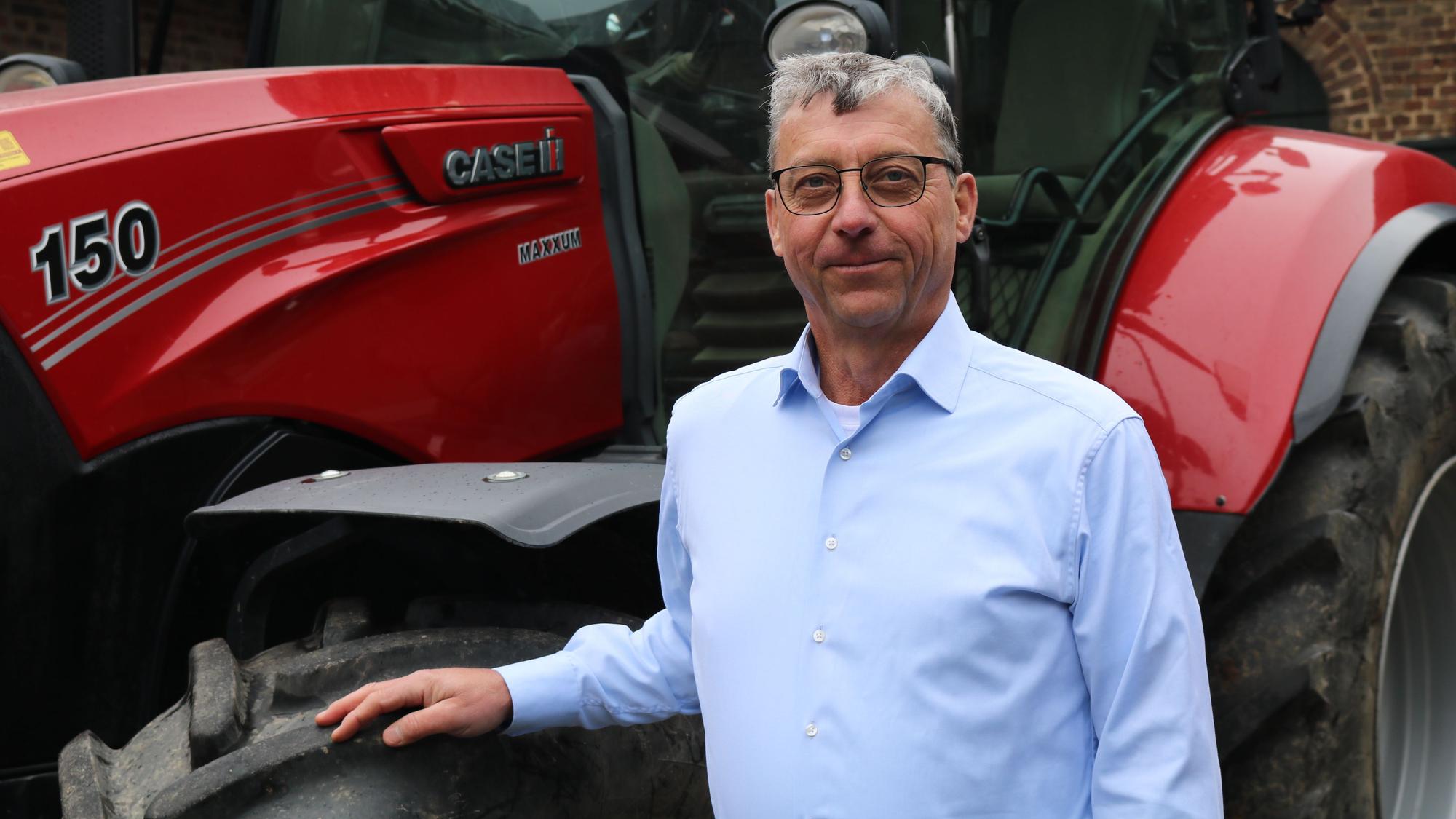 Porträt von Erich Gussen, Präsident des Rheinischen Landwirtschafts-Verbandes (RLV) vor einem Traktor