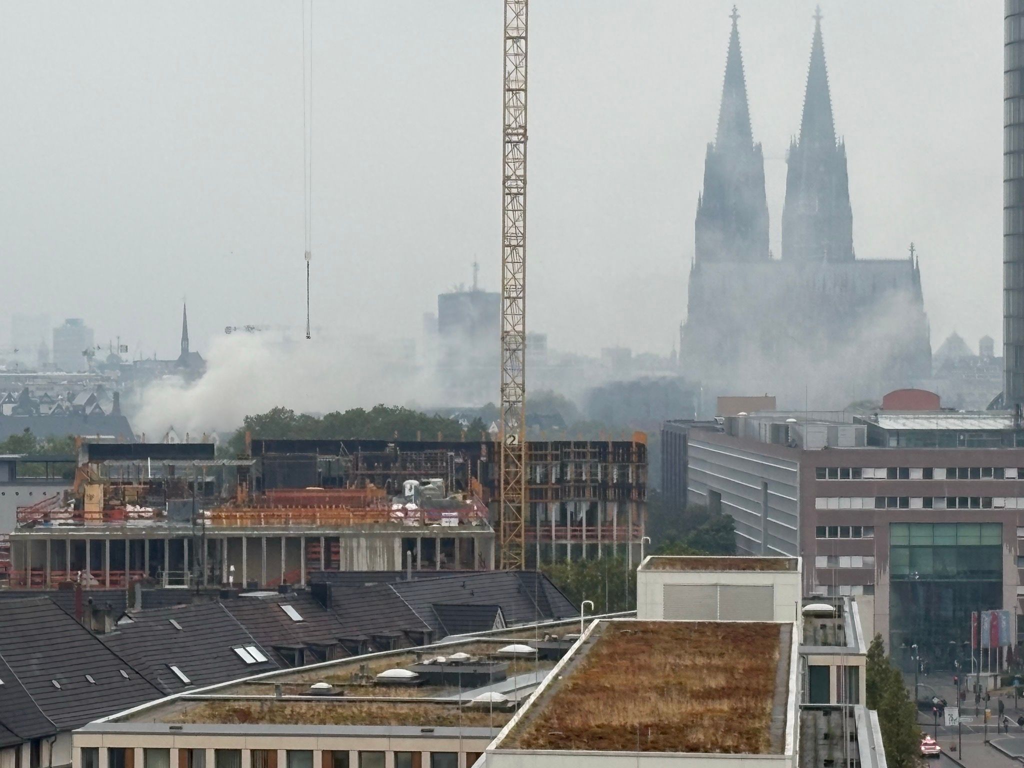 Das aus dem rechtsrheinischen Stadtgebiet aufgenommene Foto zeigt die Rauchentwicklung aufgrund des Brandes im Hotel Kunibert der Fiese