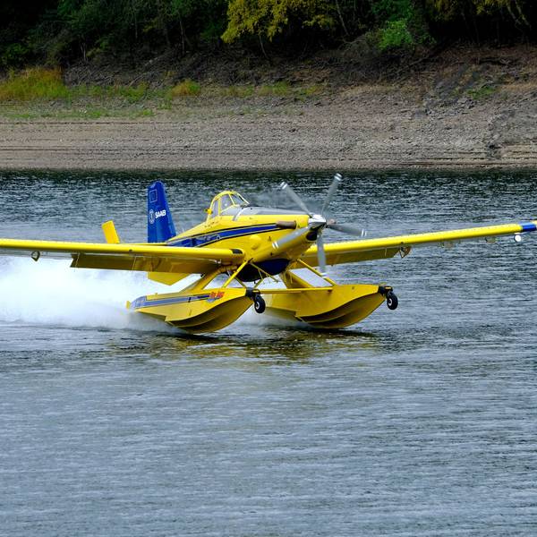 Ein gelb-blau lackiertes schwedisches Löschflugzeug wassert auf der Oleftalsperre in Hellenthal.