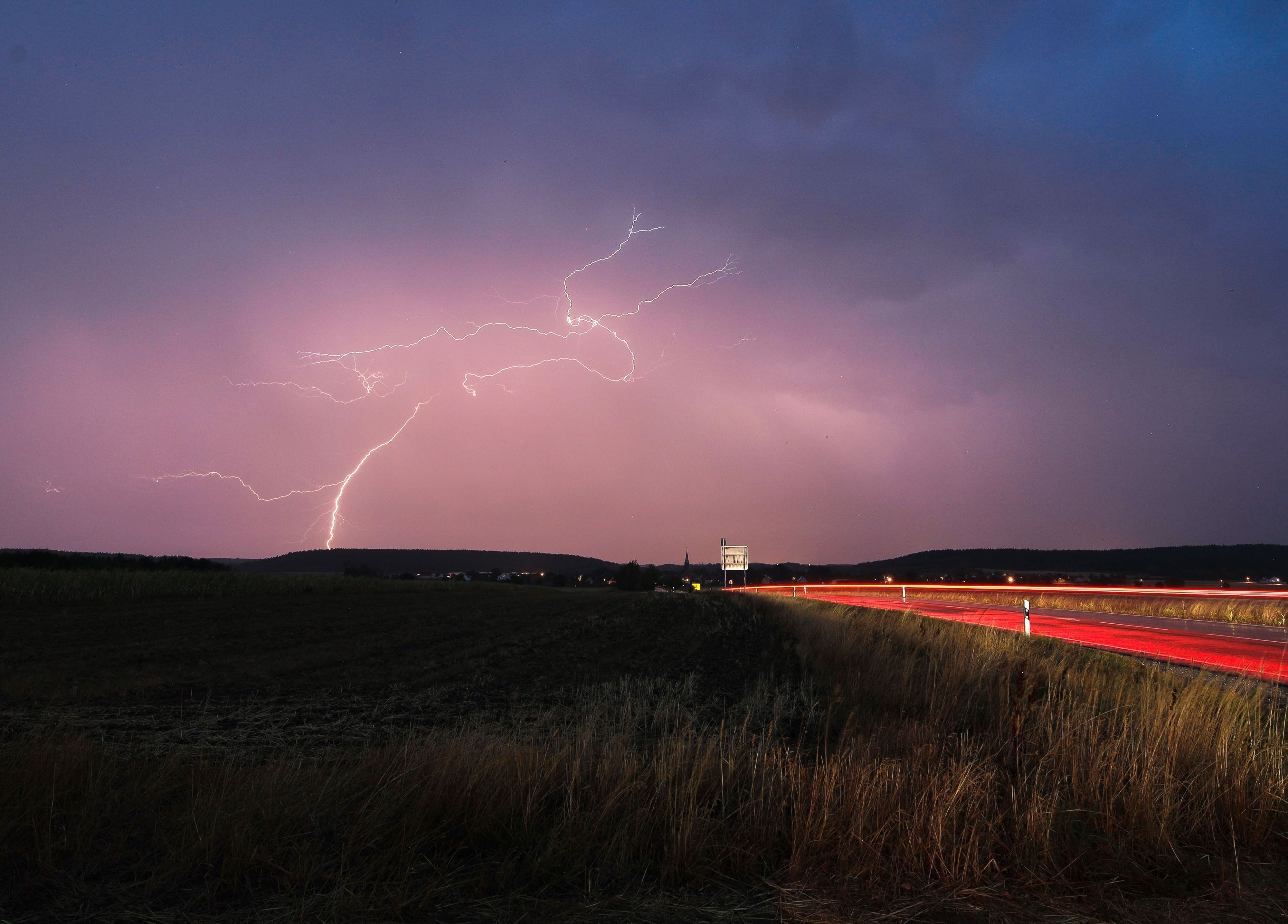 Blitze zucken bei einem abendlichen Gewitter über Mittelfranken.