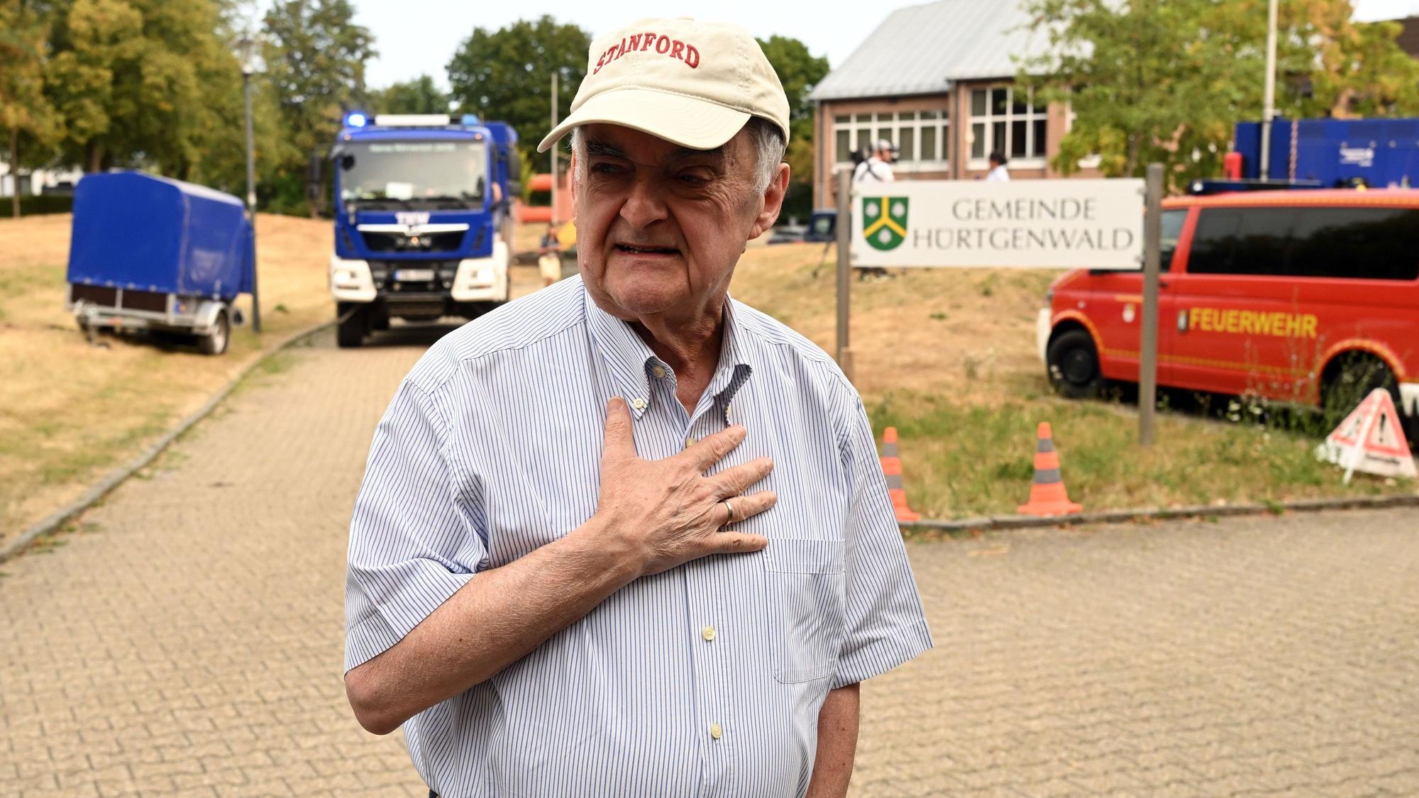 Herbert Reul (l, CDU), Innenminister von Nordrhein-Westfalen, spricht mit Journalisten bei seinem Besuch im Waldbrandgebiet im Hürtgenwald.