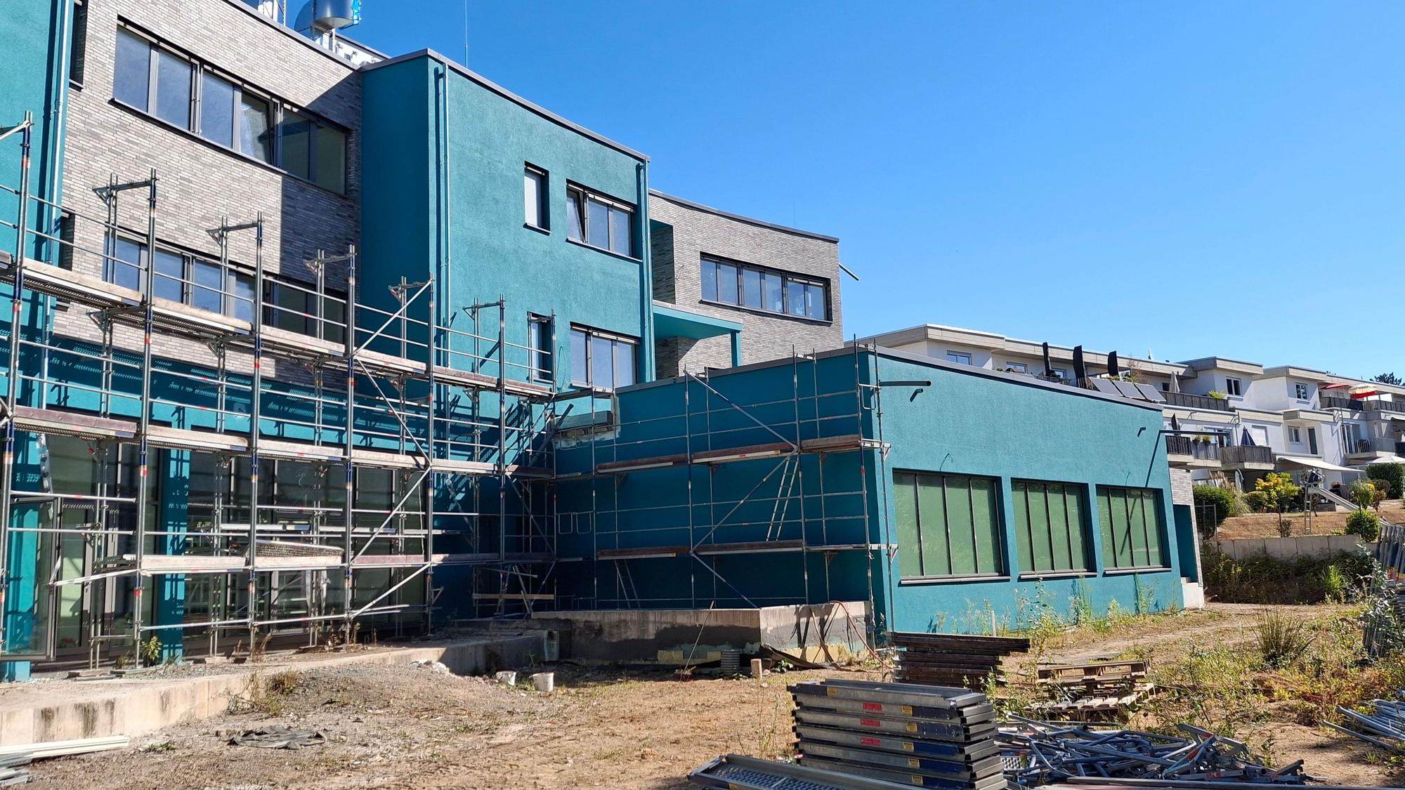 Die Baustelle besteht aus türkisen unfertigen Gebäuden, die eingezäunt sind.