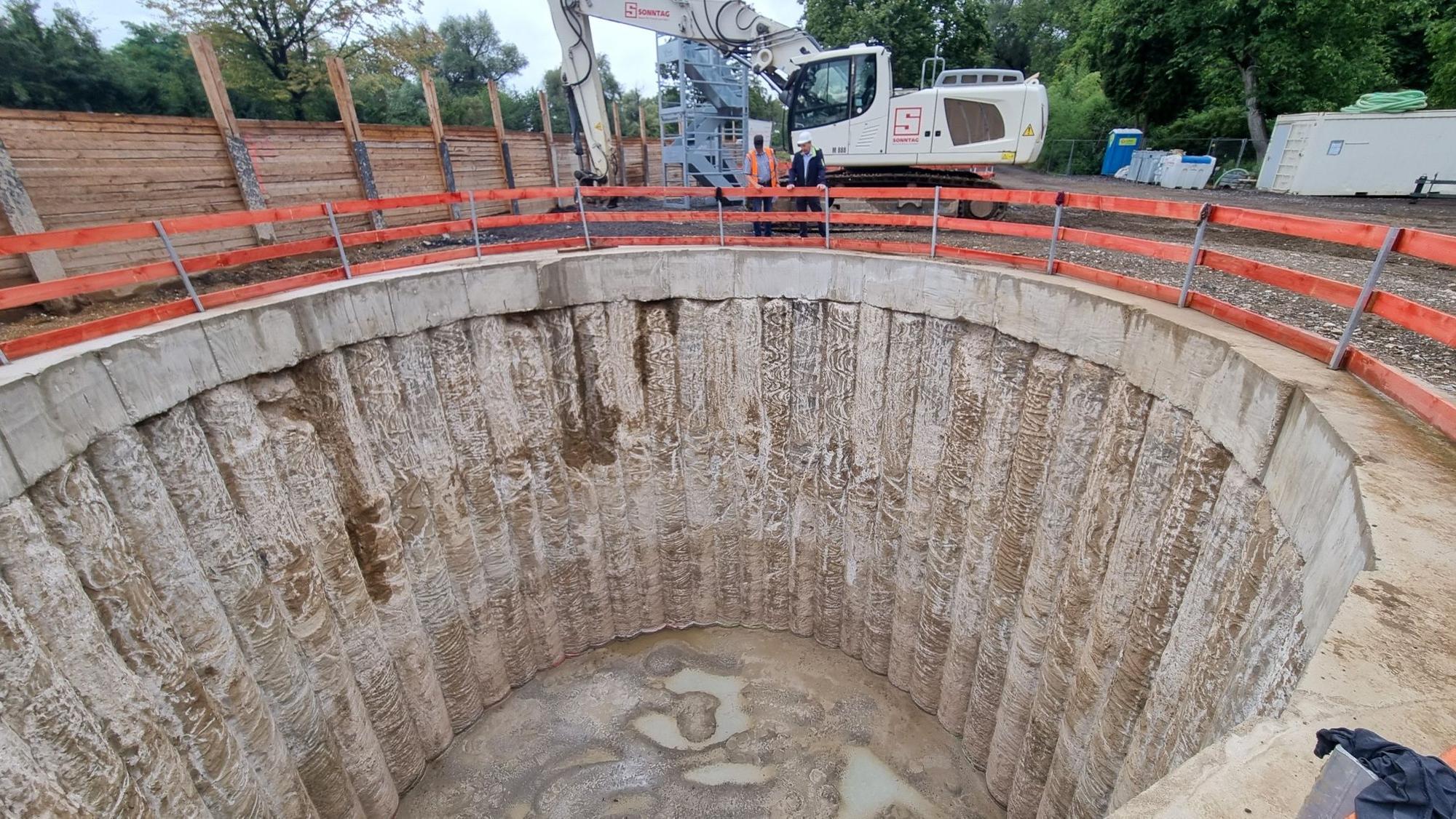 Blick in eine zehn Meter tiefe, mit Beton verkleidete Baugrube.