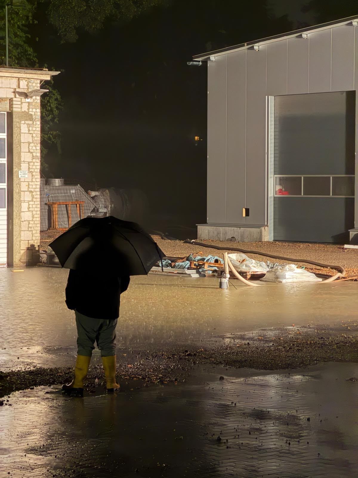 Auf dem Foto ist ein Mann mit Regenschirm zu sehen.