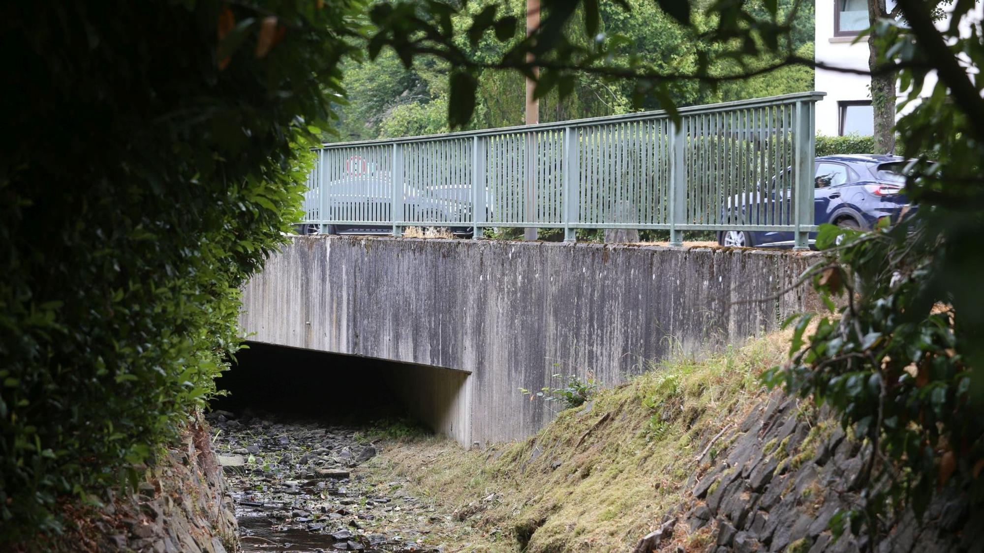 Eine Betonbrücke über einem kleinen Bach.