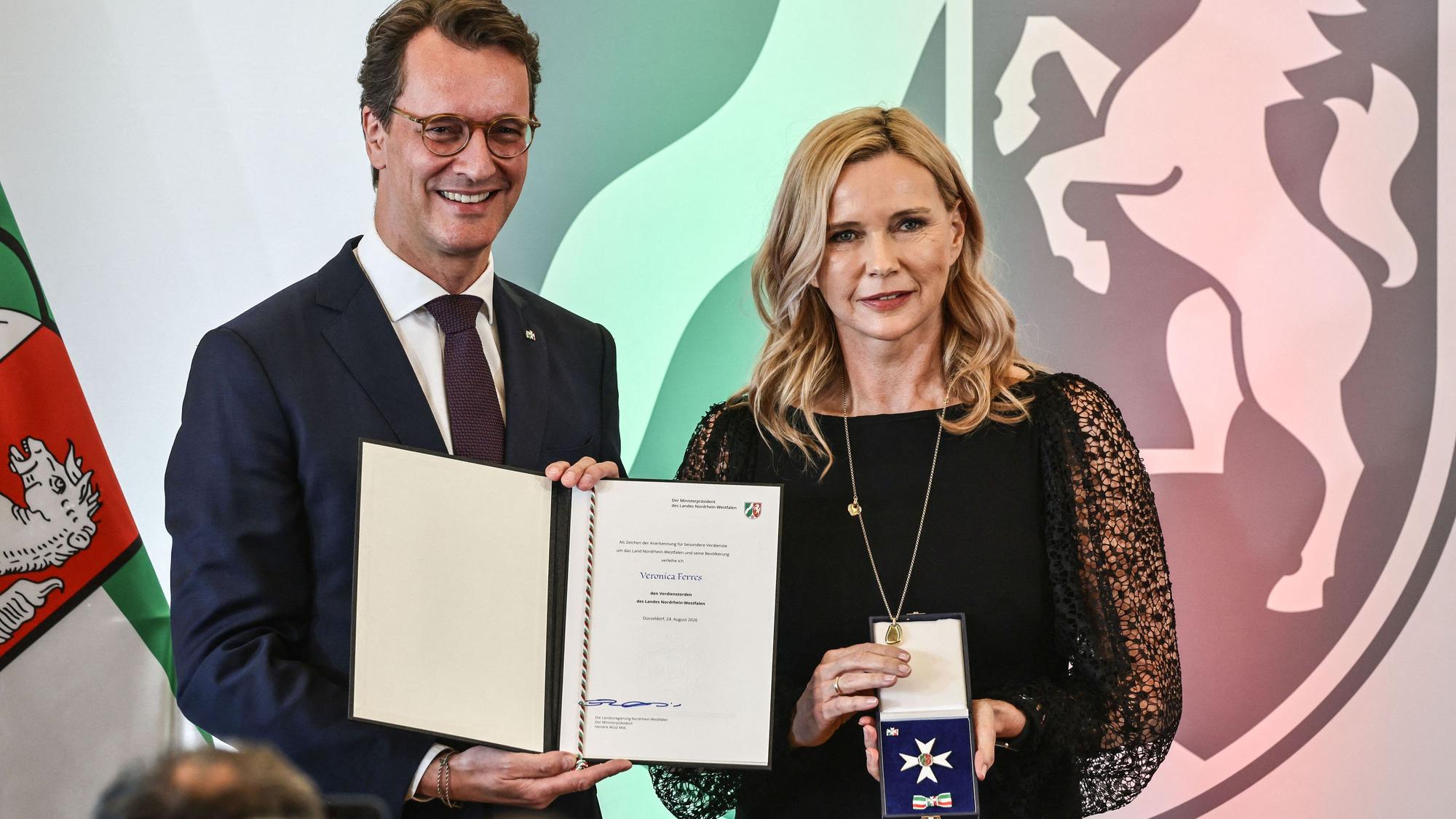 Veronica Ferres nimmt von Hendrik Wüst (CDU), Ministerpräsident von Nordrhein-Westfalen, den Landesverdienstorden entgegen.