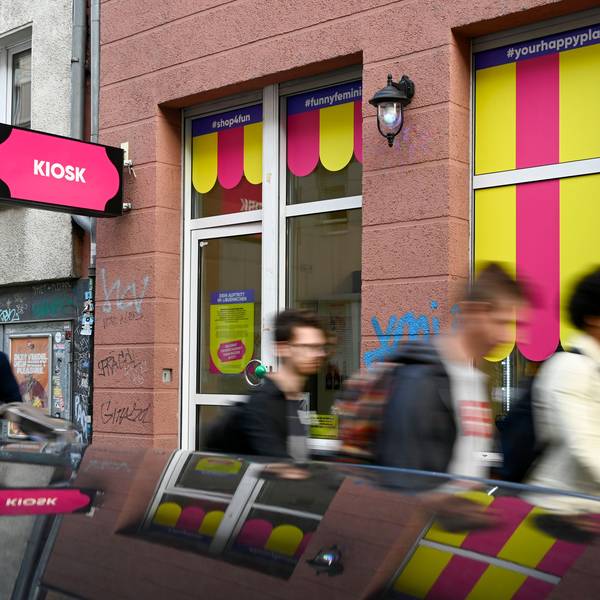 Der neue Kiosk in der Kyffhäuserstraße 15 hat am vergangenen Wochenende seine Eröffnung gefeiert. Die Schilder sind pink, es laufen mehrere Menschen daran vorbei.