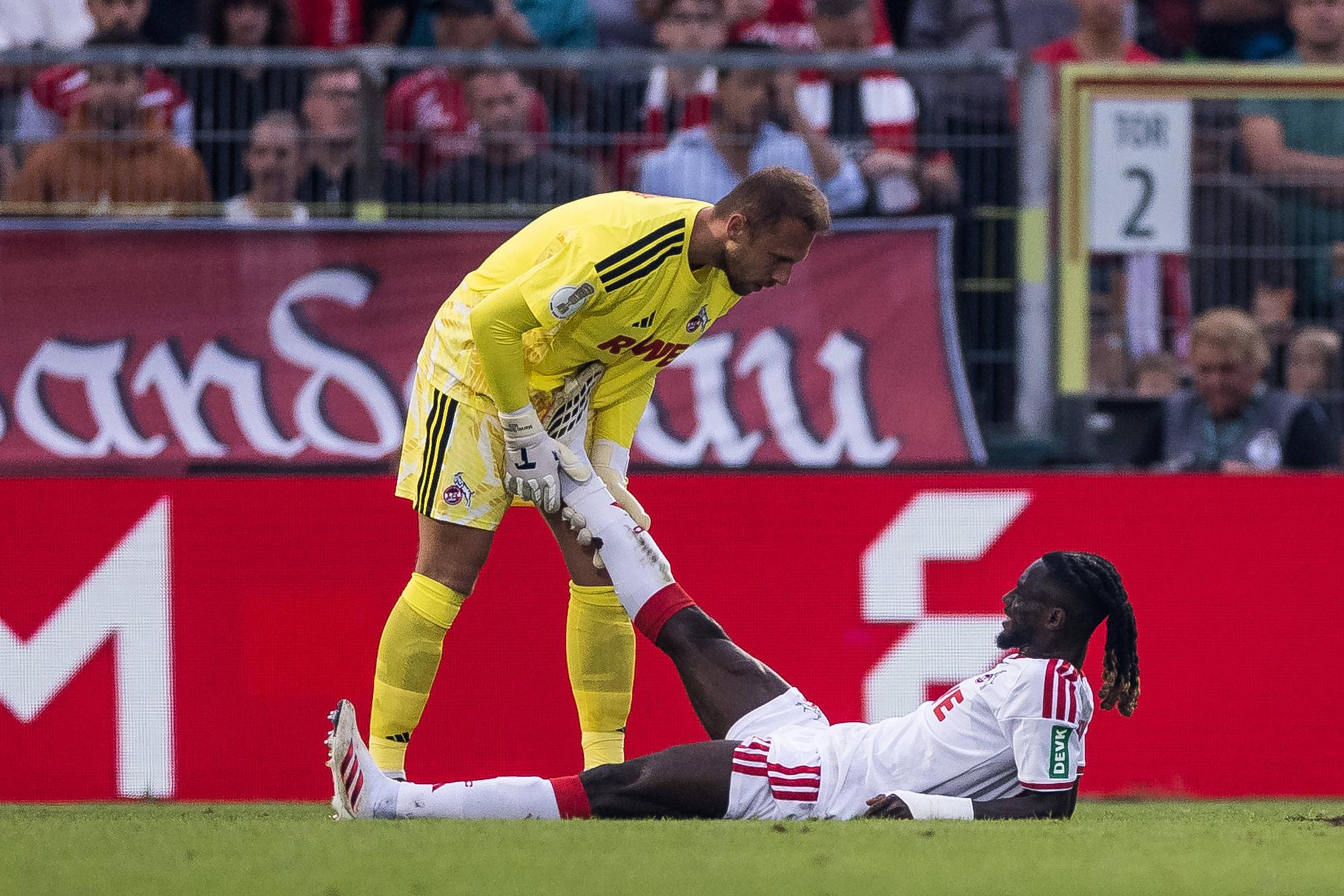 WUERZBURG, GERMANY - AUGUST 24: Marvin Schwaebe Schwäbe, Schwabe, 1. FC Koeln, 1 helping Gideon Mensah 1. FC Koeln, 14 during the 1st round DFB Pokal match between Wuerzburger Kickers vs. 1. FC Koeln at AKON ARENA on August 24, 2026 in Wuerzburg, Germany. DFB REGULATIONS PROHIBIT ANY USE OF PHOTOGRAPHS AS IMAGE SEQUENCES AND/OR QUASI-VIDEO. Bavaria Germany Copyright: xSteffiexWunderlx