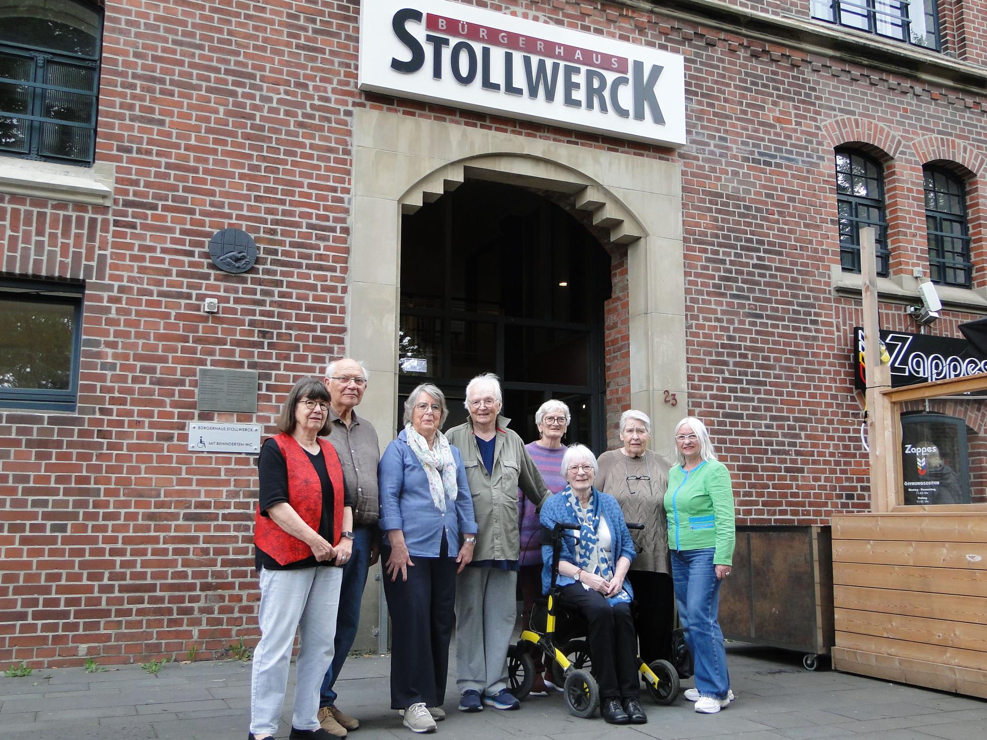 Eine Gruppe Männer und Frauen steht vor dem Eingang des Stollwerck.