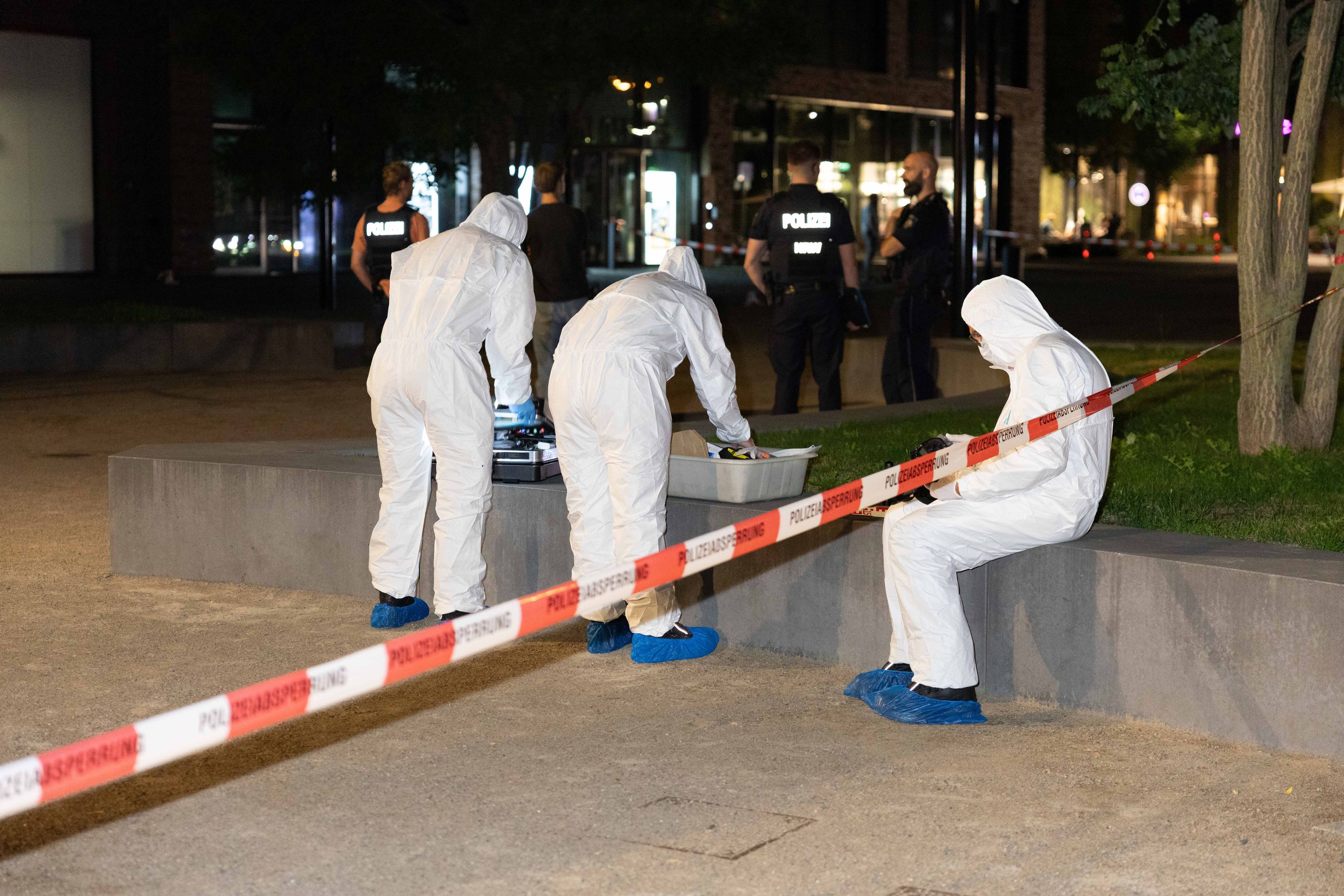 Einsatzkräfte der Polizei untersuchen nach dem Schuss auf einen 41-Jährigen den Tatort in Köln-Mülheim.