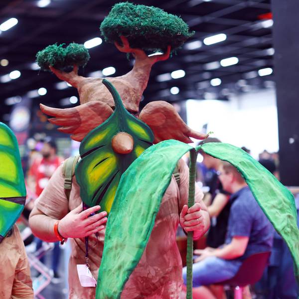 Vor der Kamera stehen zwei Menschen, die als kleine Baumwesen verkleidet zur Gamescom gekommen sind.