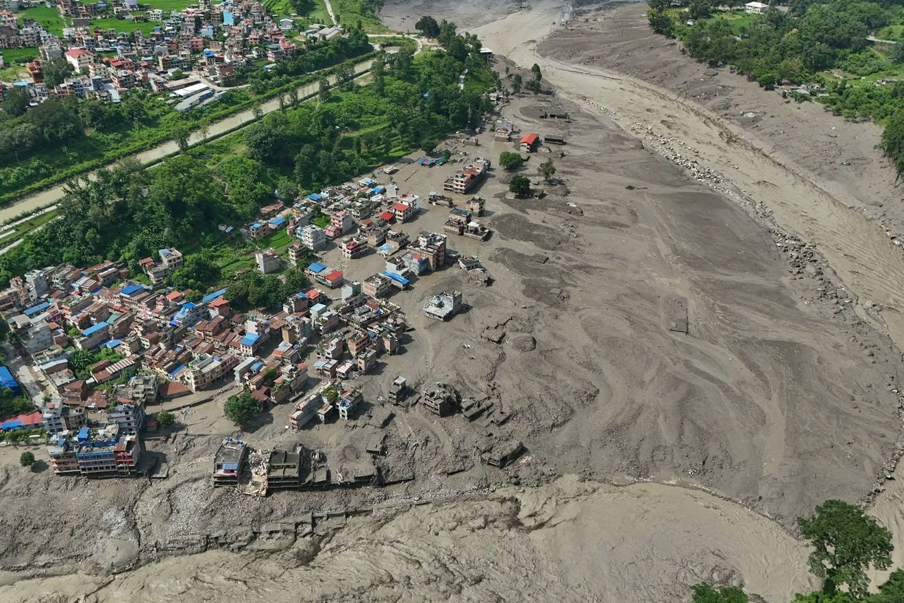 Nach Sturzfluten im nepalesischen Distrikt Nuwakot stehen beschädigte Häuser gefährlich nahe an den angeschwollenen, mit Treibgut verstopften Ufern des Trishuli-Flusses.