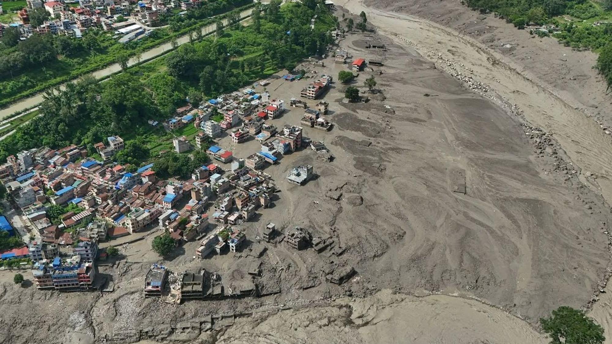 Nach Sturzfluten im nepalesischen Distrikt Nuwakot stehen beschädigte Häuser gefährlich nahe an den angeschwollenen, mit Treibgut verstopften Ufern des Trishuli-Flusses.