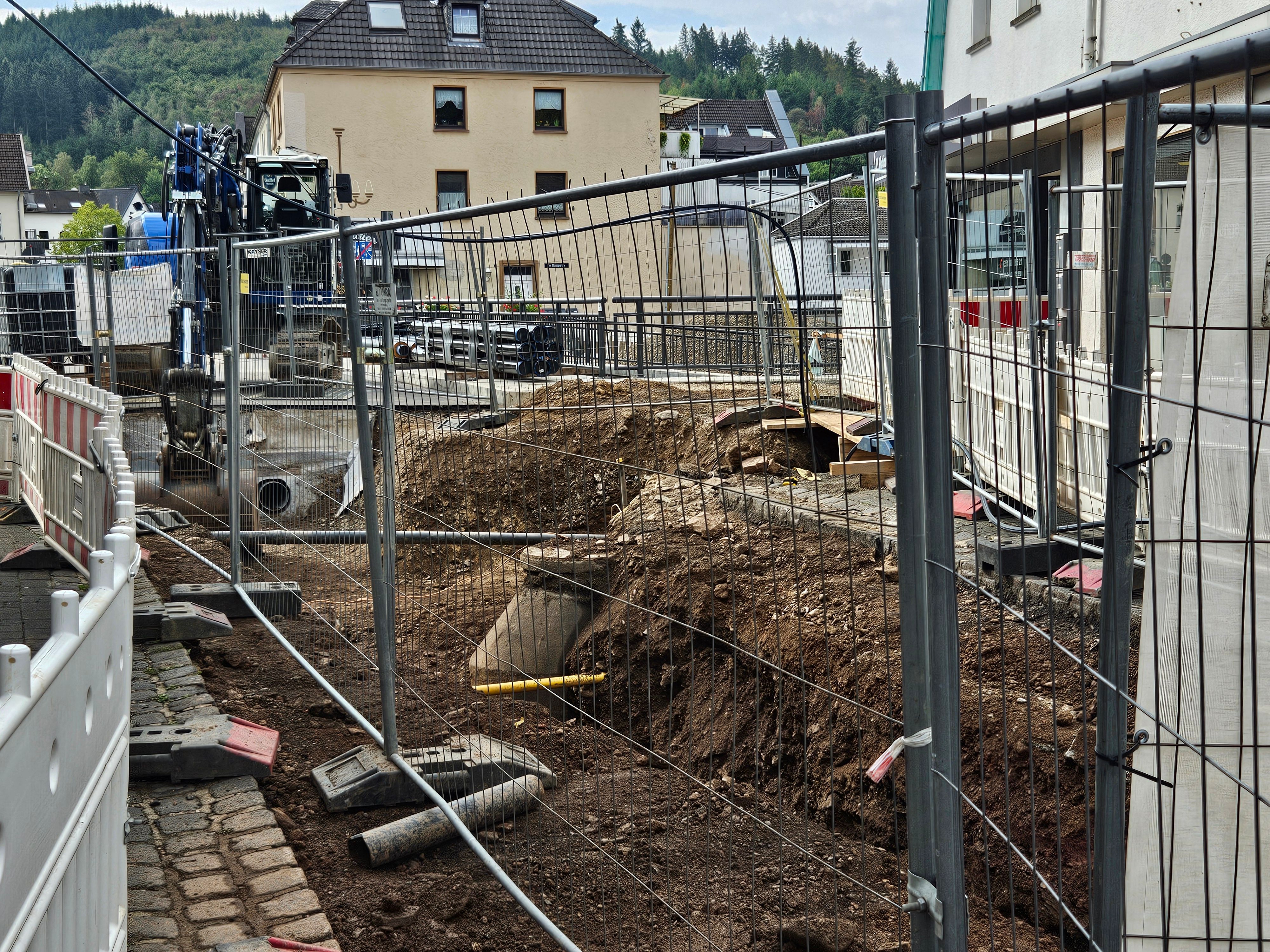 Zu sehen sind die aufgerissene Straße vor der Brücke und ein Bagger.
