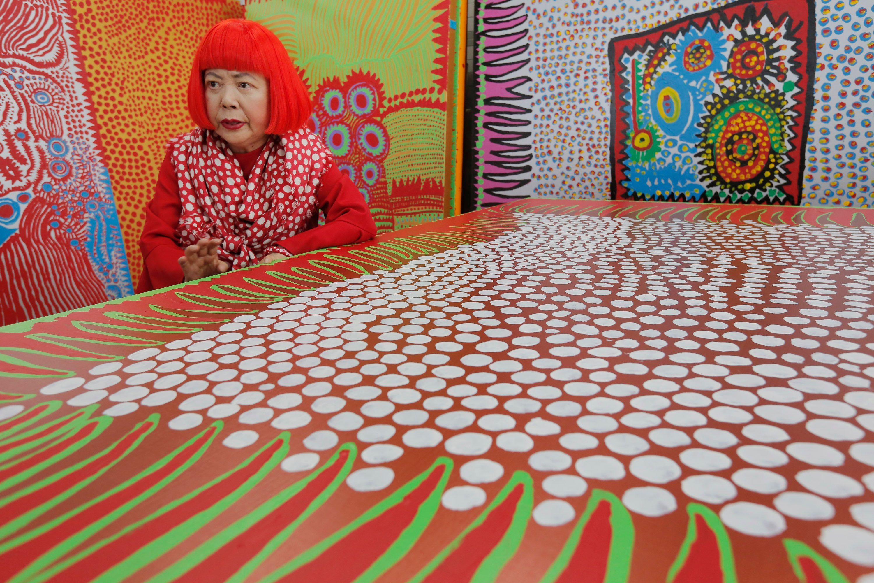 Die japanische Künstlerin Yayoi Kusama spricht während eines Interviews in ihrem Atelier, das mit wandgroßen Gemälden gefüllt ist.