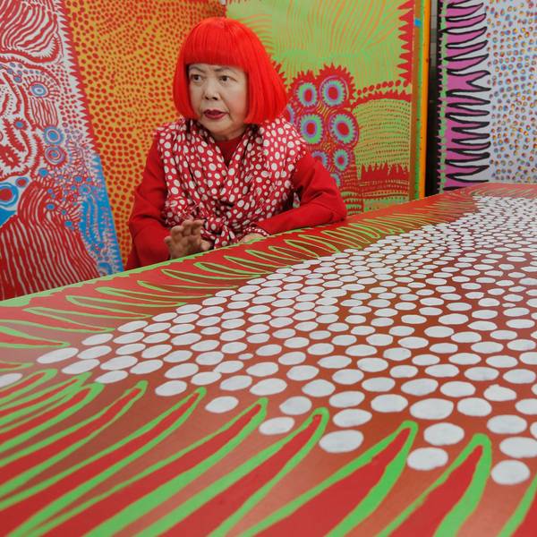 Die japanische Künstlerin Yayoi Kusama spricht während eines Interviews in ihrem Atelier, das mit wandgroßen Gemälden gefüllt ist.