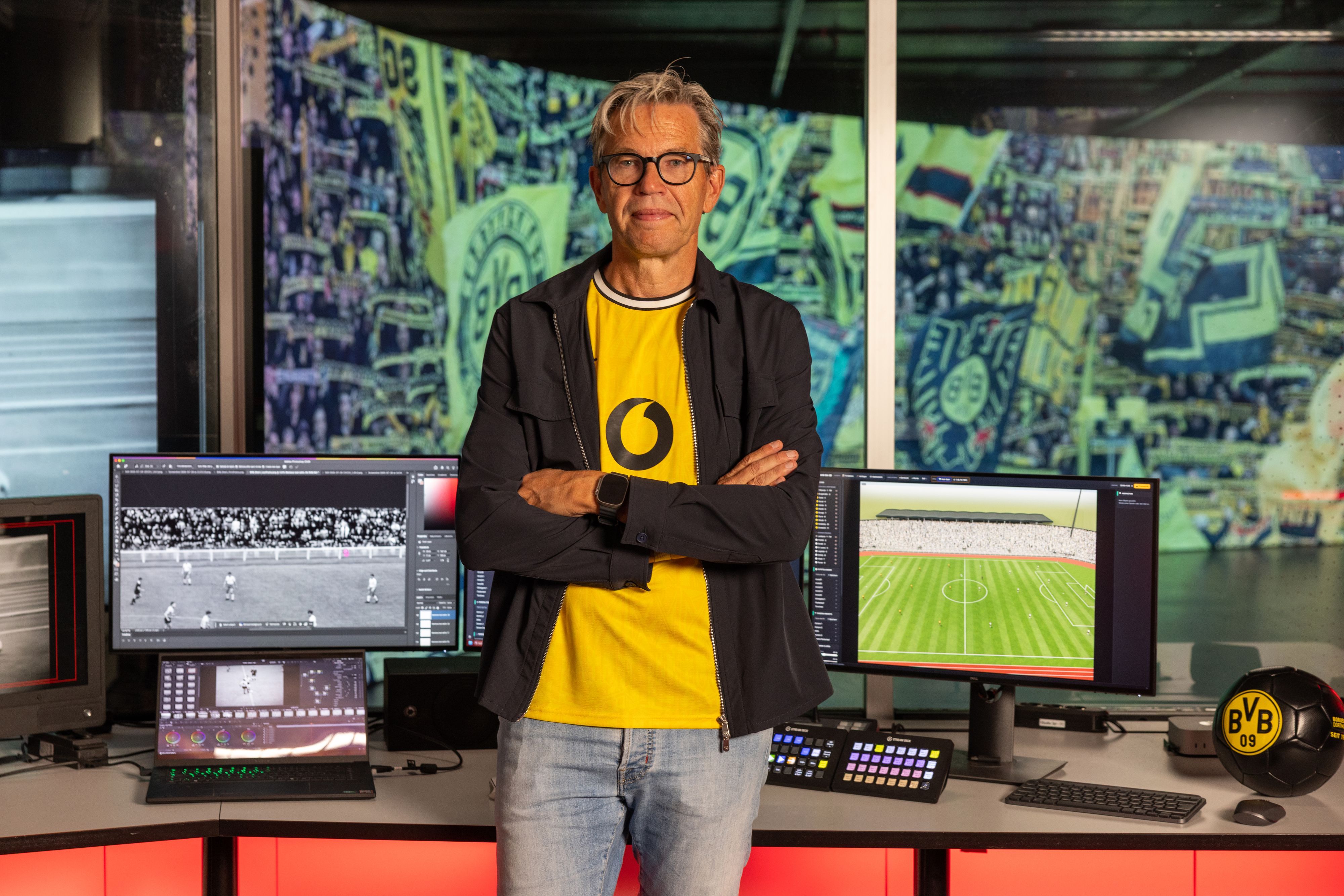 CEO Marcel de Groot steht in einem gelben BVB-Trikot vor Bildschirmen, auf denen die Rekonstruktion des Tors läuft.