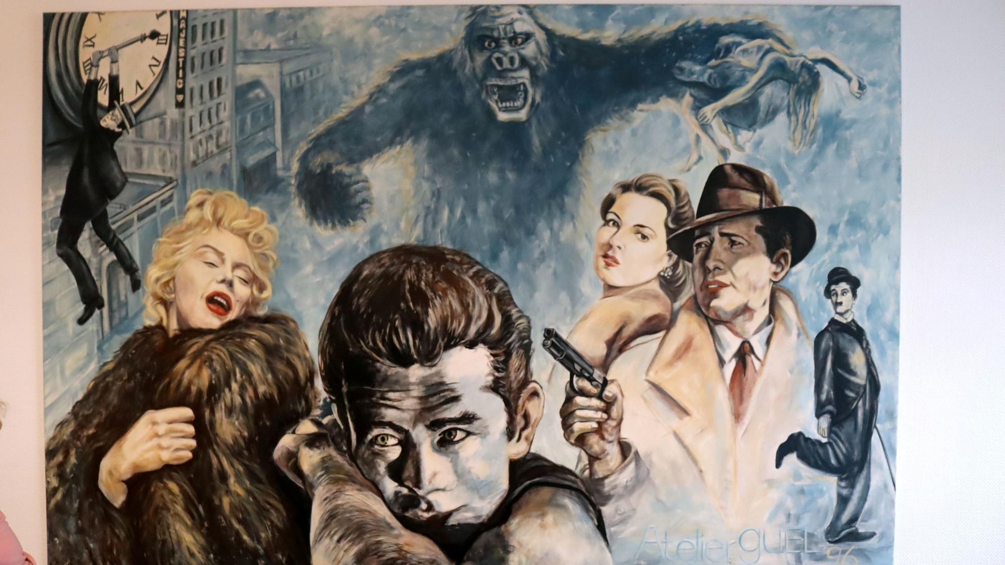 Auf einer Leinwand sind Buster Keaton, Marilyn Monroe, James Dean, Ingrid Bergman, Humphrey Bogart, Charles Chaplin und King Kong zu sehen.
